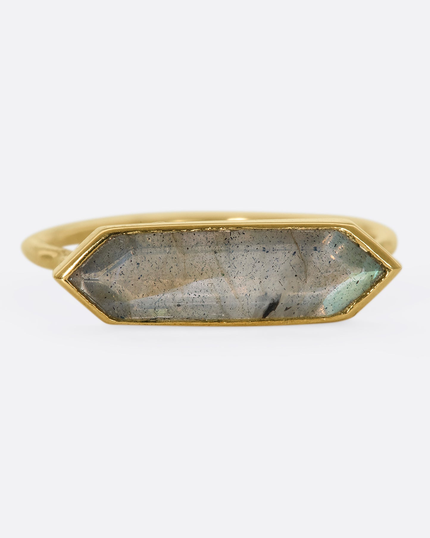 A yellow gold ring with a hexagonal labradorite bar, shown from the front.