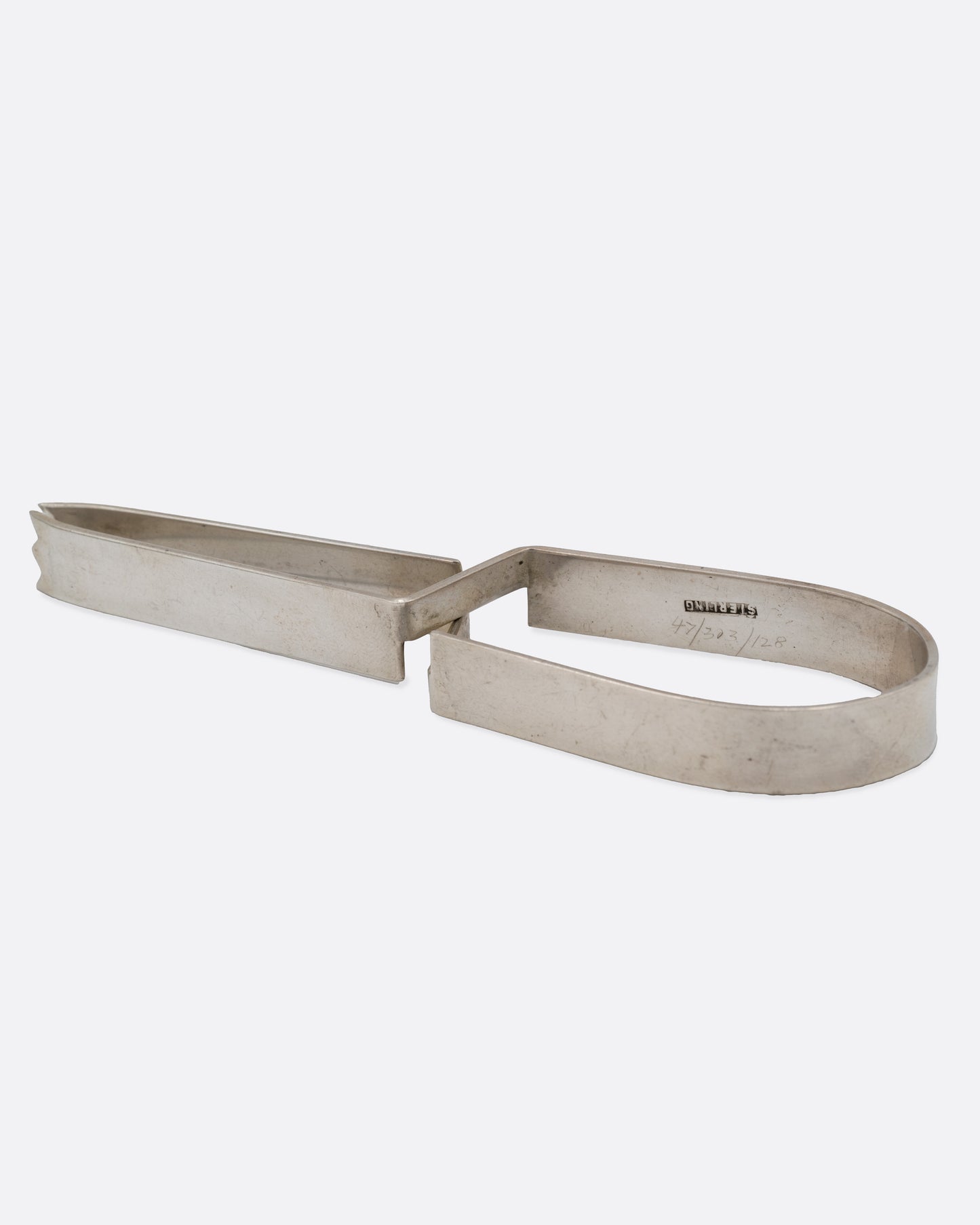Stainless steel ice tongs with an arched handle, shown on their side.