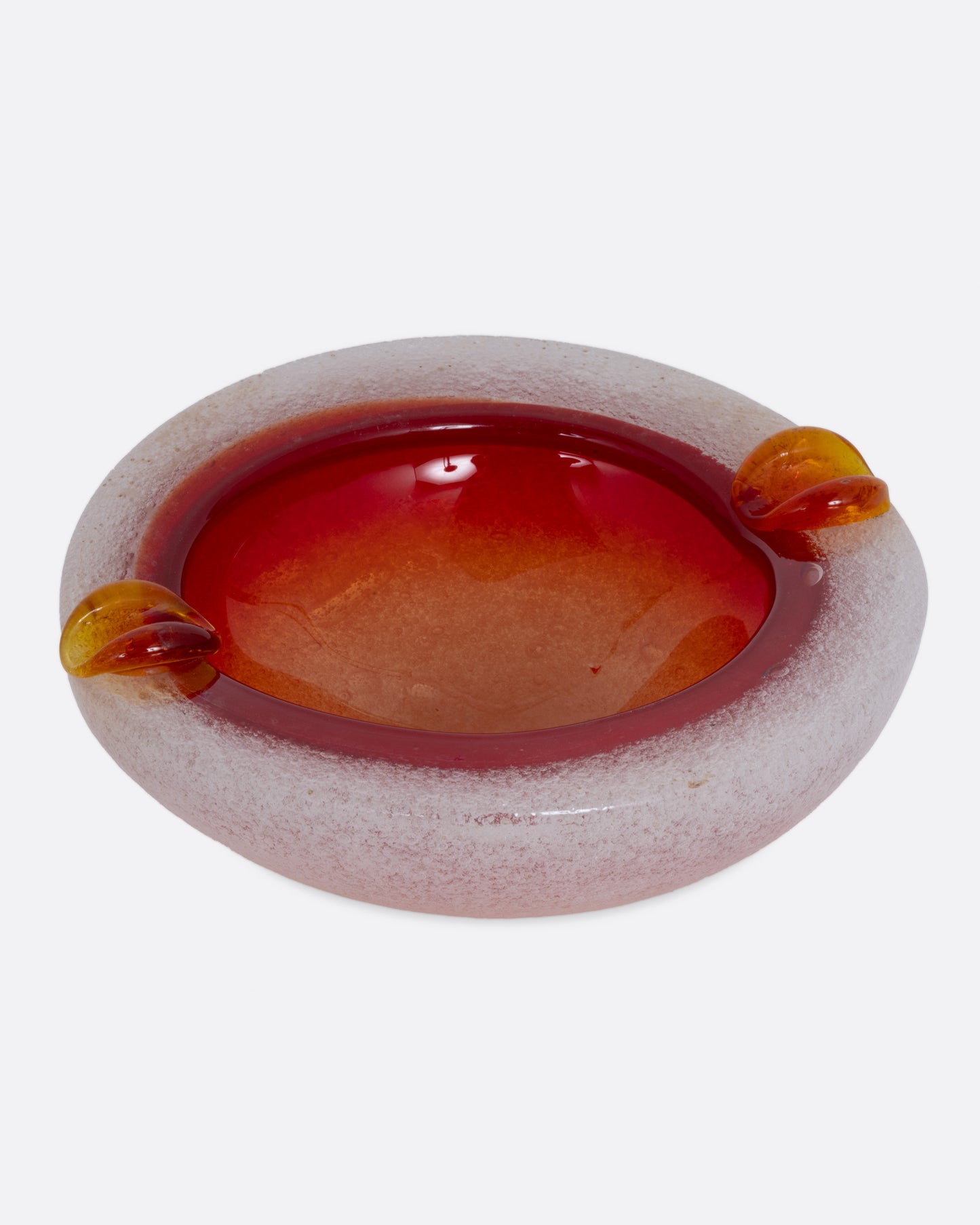 An orange and white blown glass ashtray, shown from the front.