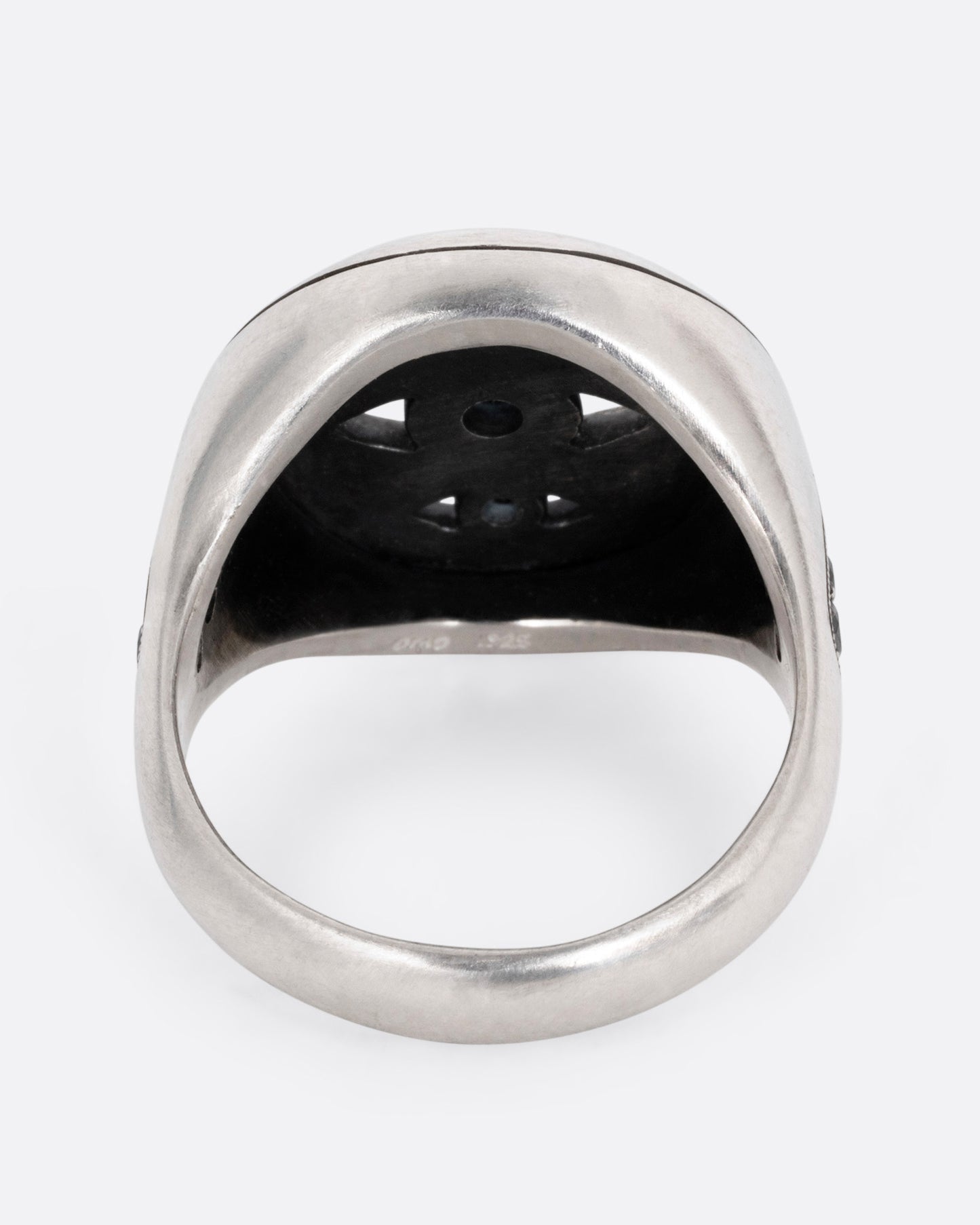 A silver ring with three eyes with black diamond centers, shown from the back.