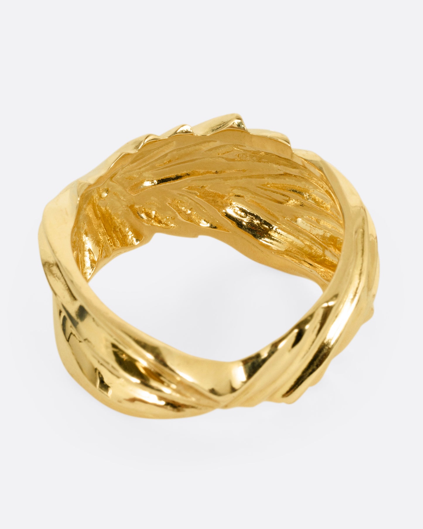 A yellow gold ring with wavy and chevron textures, shown from the back.