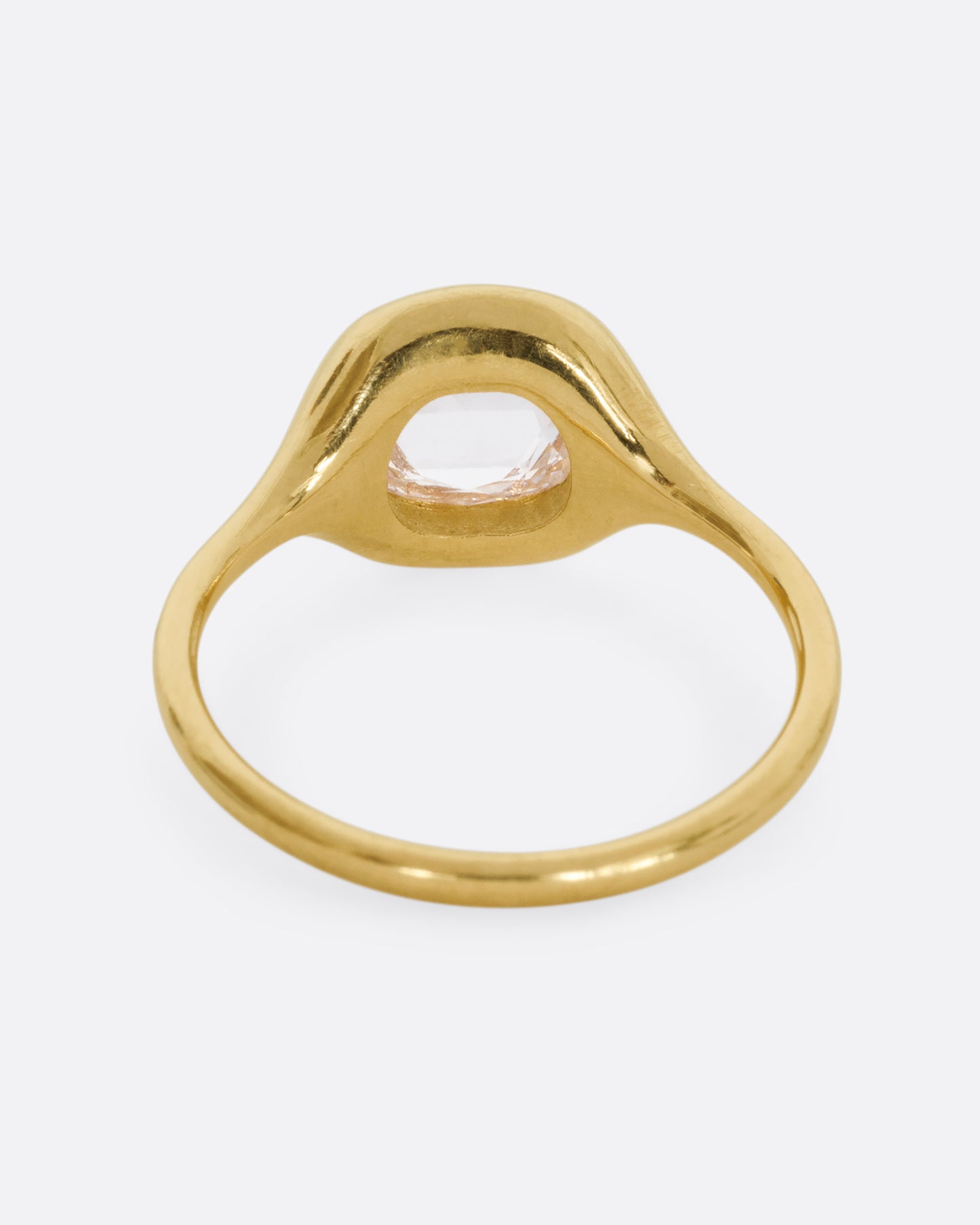 A yellow gold hand carved ring with a brilliant rose cut diamond. Shown from the back.