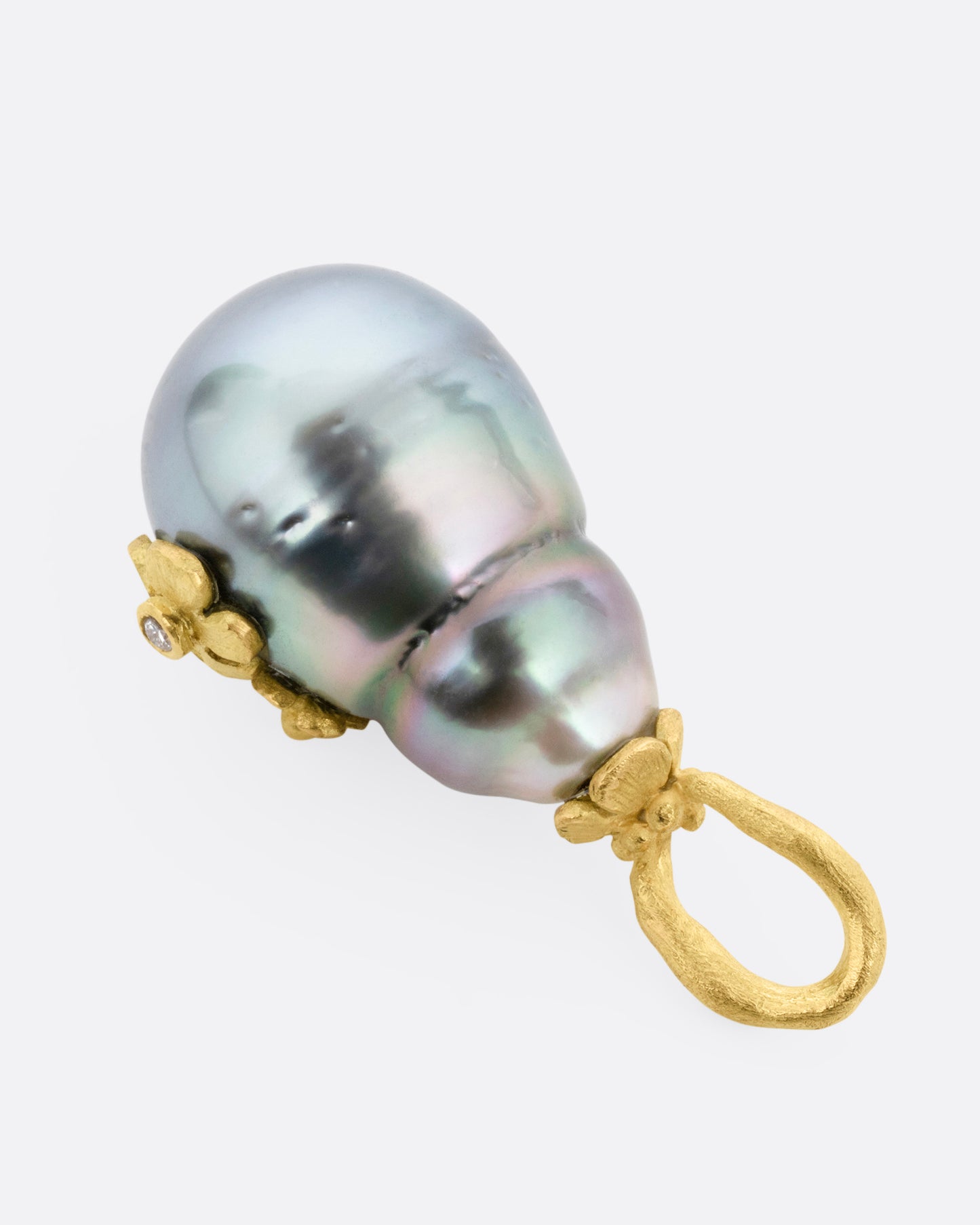 A yellow gold Tahitian pearl pendant with diamond accented flower details, shown from the back.