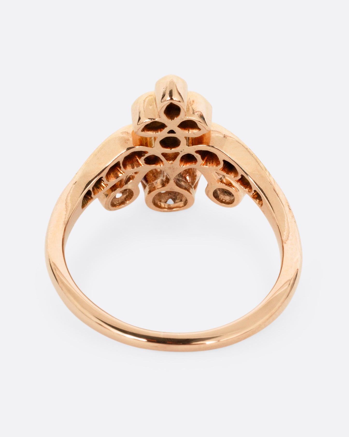 A rose and yellow gold ring with hand cut Old European diamonds in varying sizes, shown from the back.