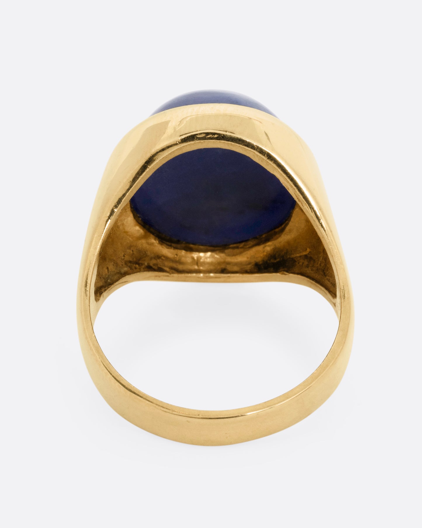 A yellow gold signet ring with a lapis cabochon, shown from the back.