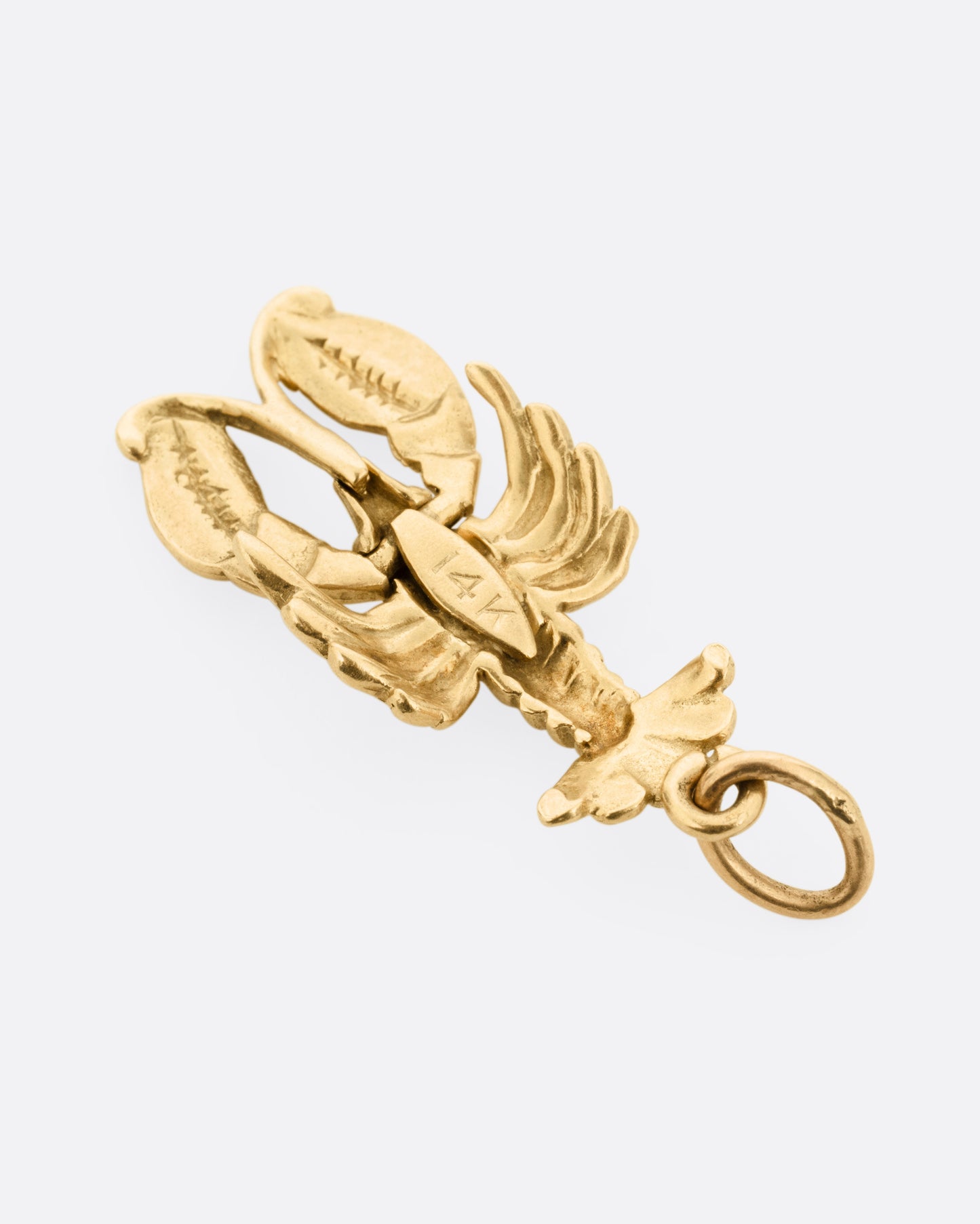 A yellow gold lobster charm, shown from the back.