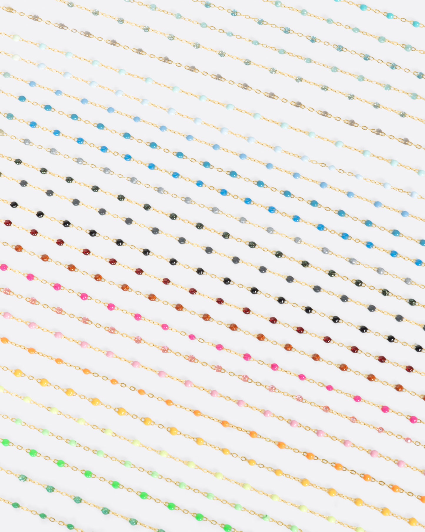 A photo of numerous yellow gold chains with different colors of resin beads.