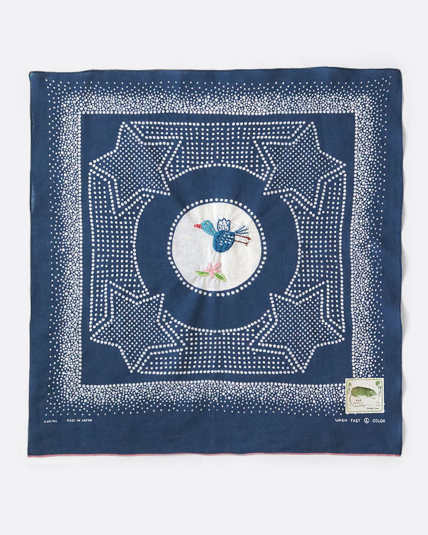 A blue bandana with a spotted star motif and a hand- embroidered magpie at the center. Shown from the front.