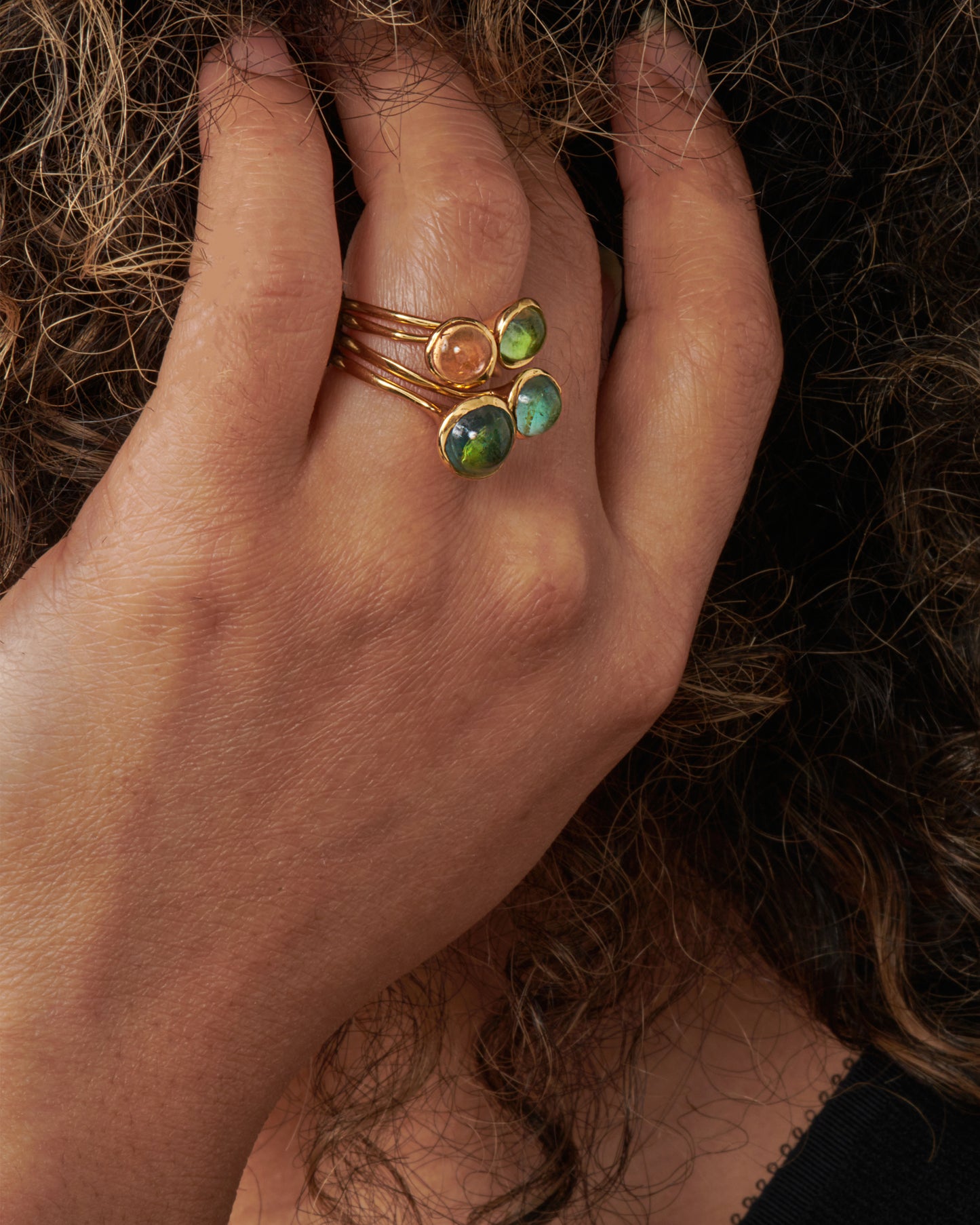 A wonky gold ring with a blue tourmaline cabochon set atop it.