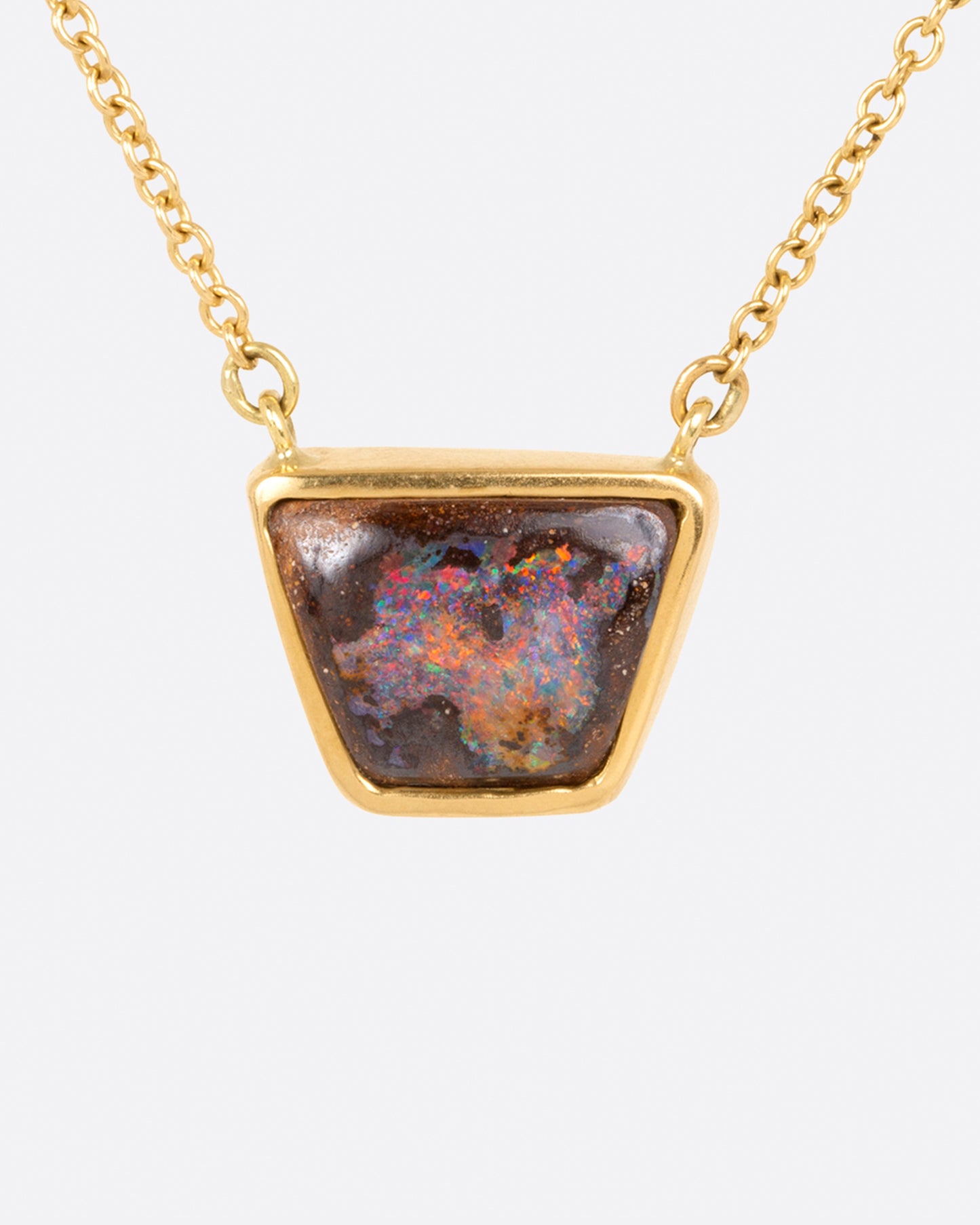 A yellow gold cable chain necklace with a trapezoidal opal set in a bezel. Shown from the front.