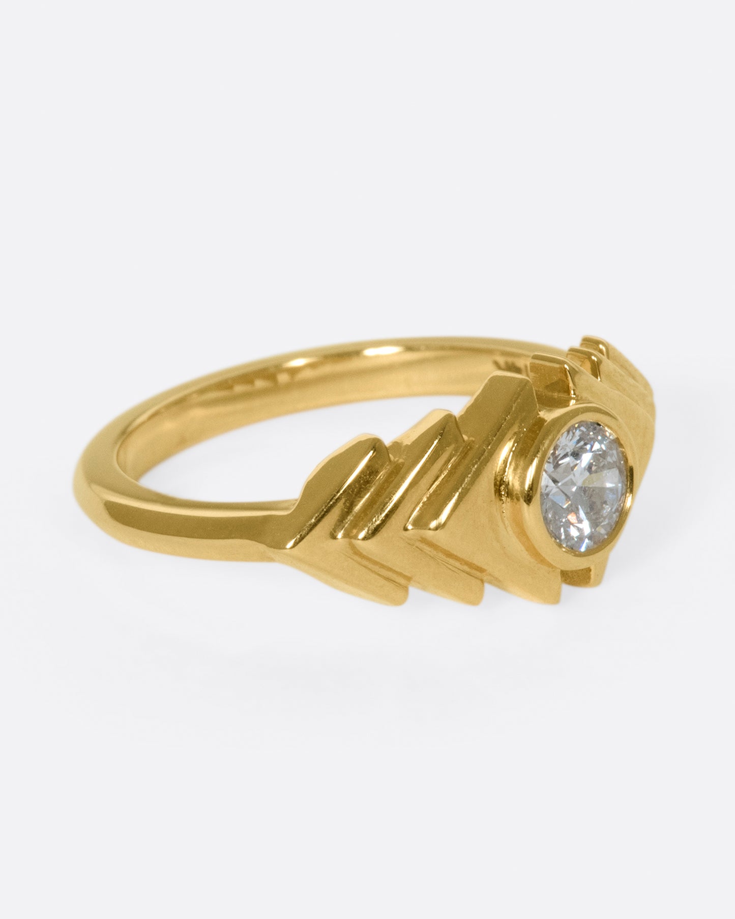 This ring takes cues from tribal kilim pieces, featuring a round diamond contrasting with a repetitive triangular motif