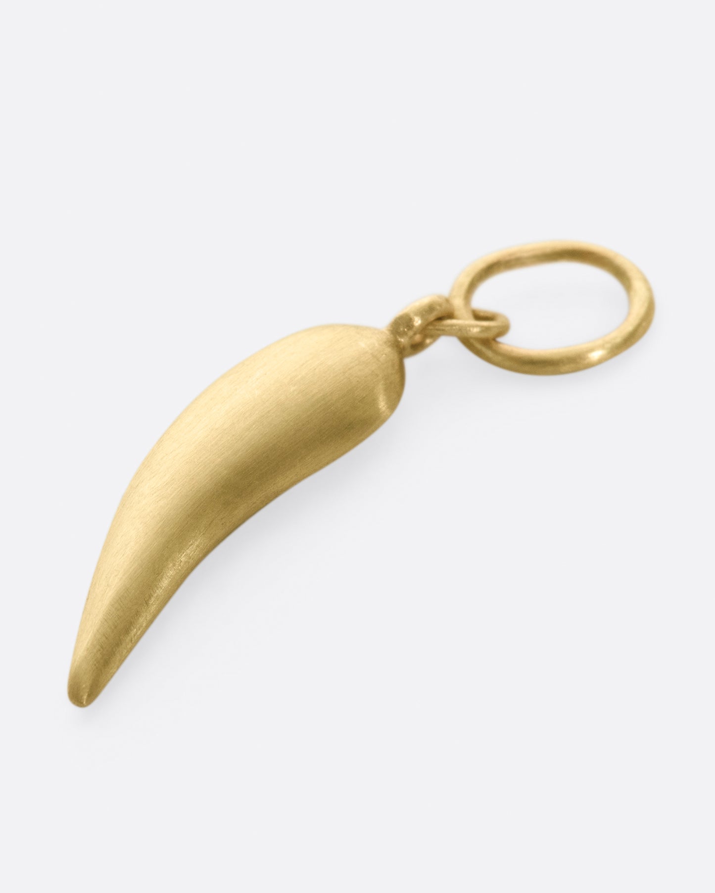 A yellow gold chili shaped charm with five graduated black diamonds. Shown laying flat, from the back.