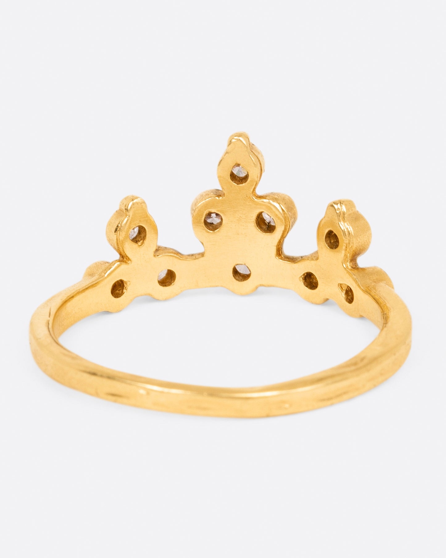 A yellow gold crown ring with peaks of round white diamonds, shown from the back.