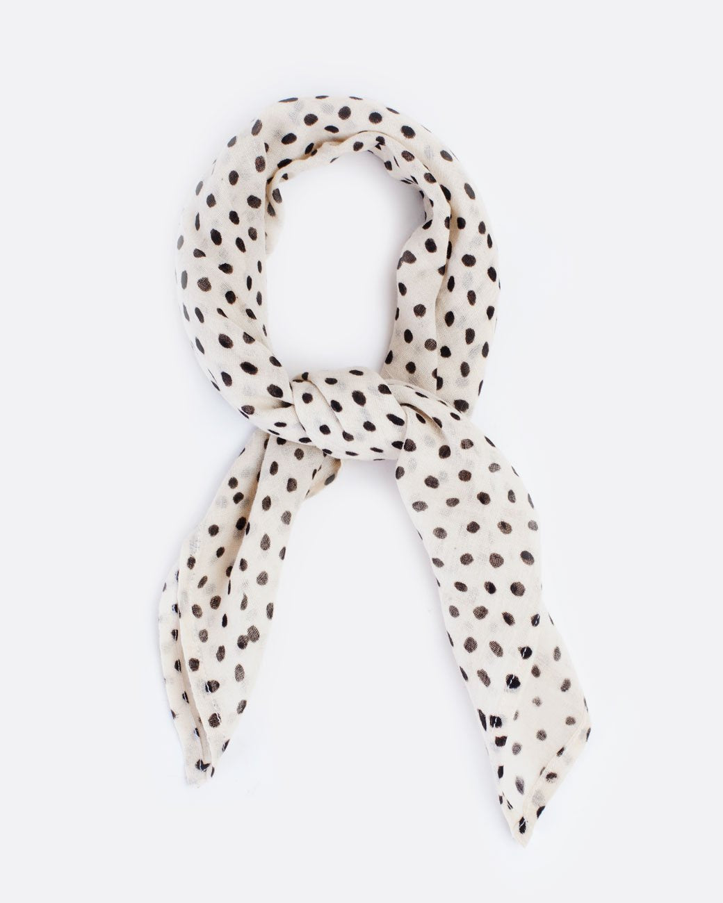 Cream bandana with black polka dots, shown tied.