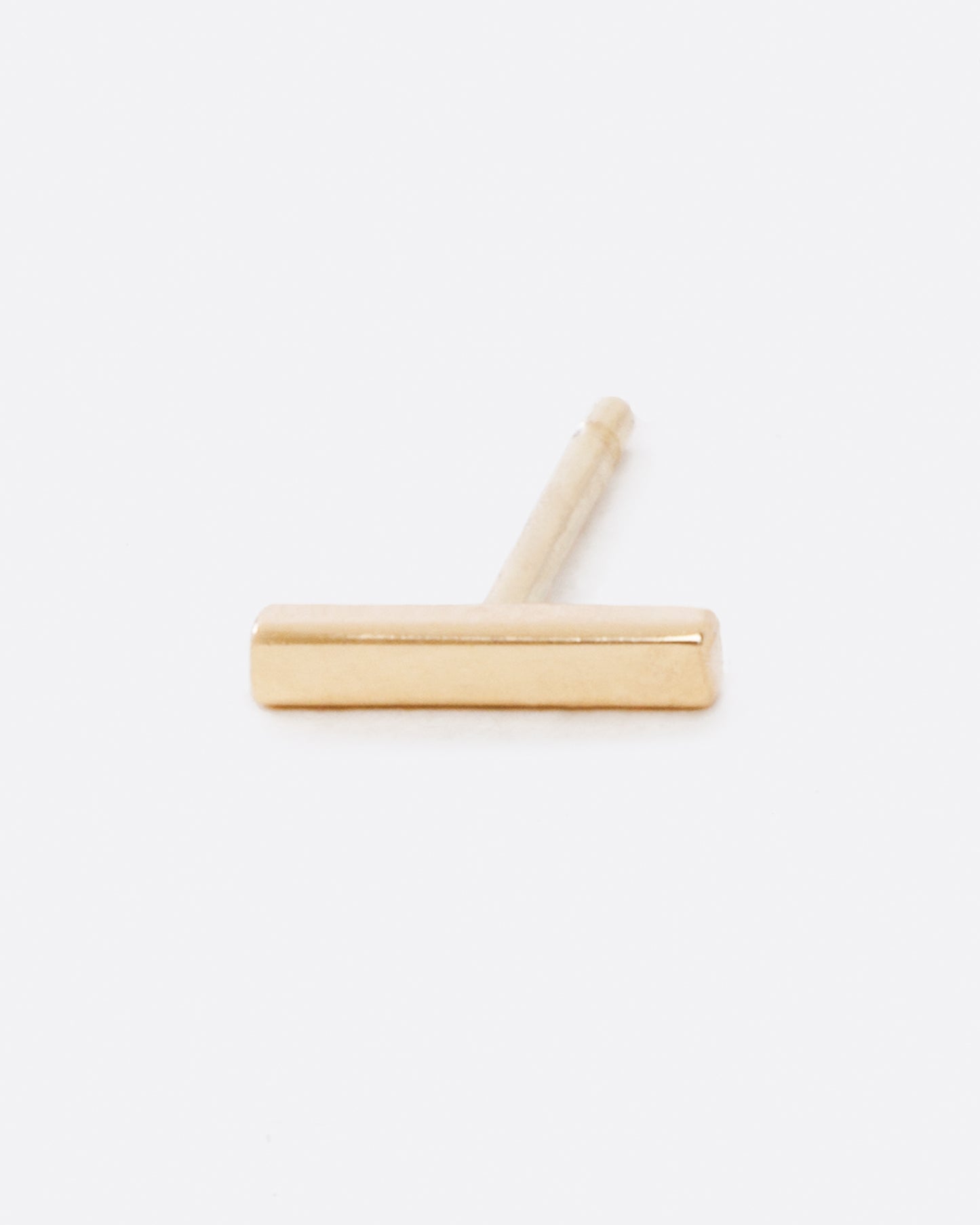 A yellow gold bar earring, shown lying on its side from the front.