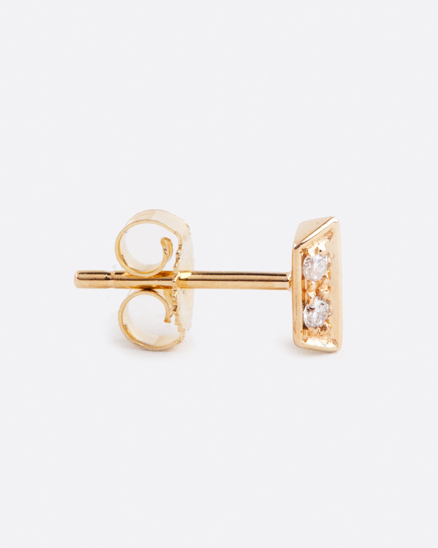 A yellow gold bar stud earring with two angled sides and four diamonds. Shown standing up from the side.