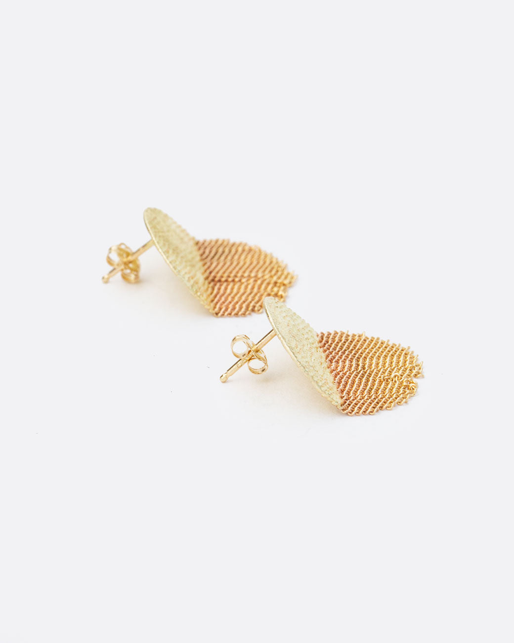 A pair of gold earrings with soldered half circle tops and chain fringe half circle bottoms. Shown from the side.