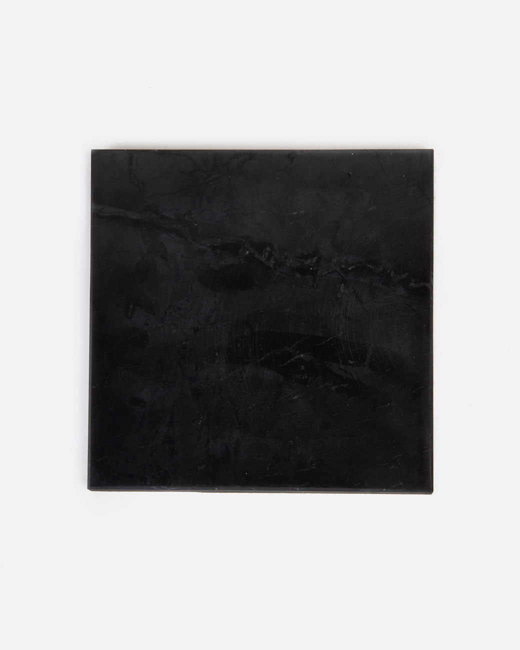 A black stone tile shown lying flat from the top.