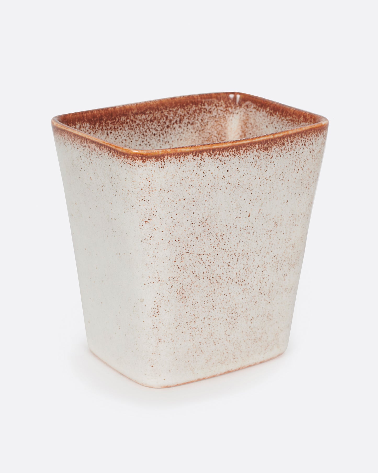 A warm white vase with brown speckles.