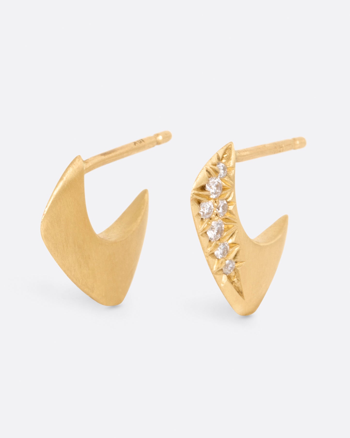 A pair of yellow gold angular huggie hoop earrings with round pave diamonds on the outside of each, shown from the side.