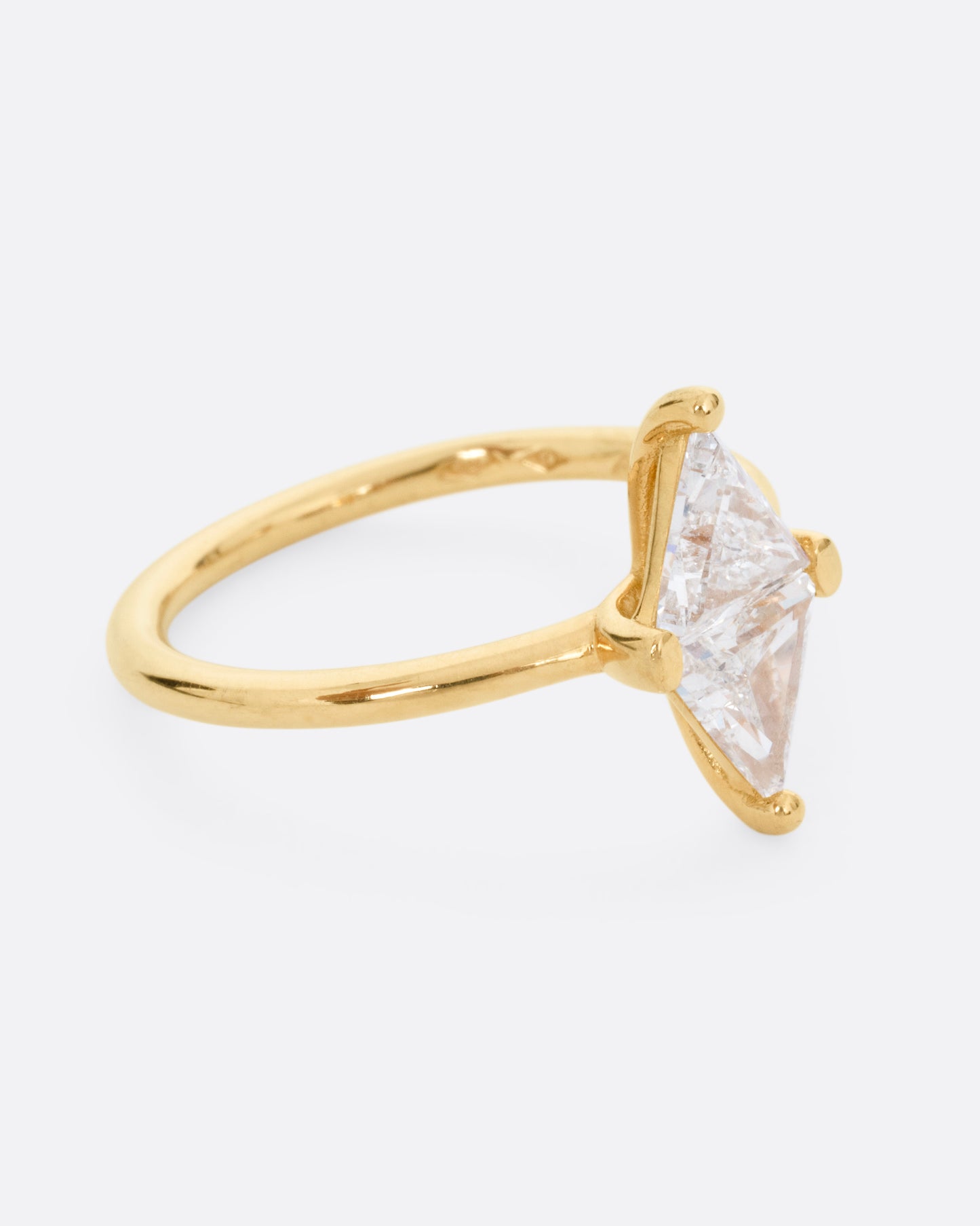 A yellow gold ring with two triangular diamonds mirroring each other. Shown from the side.