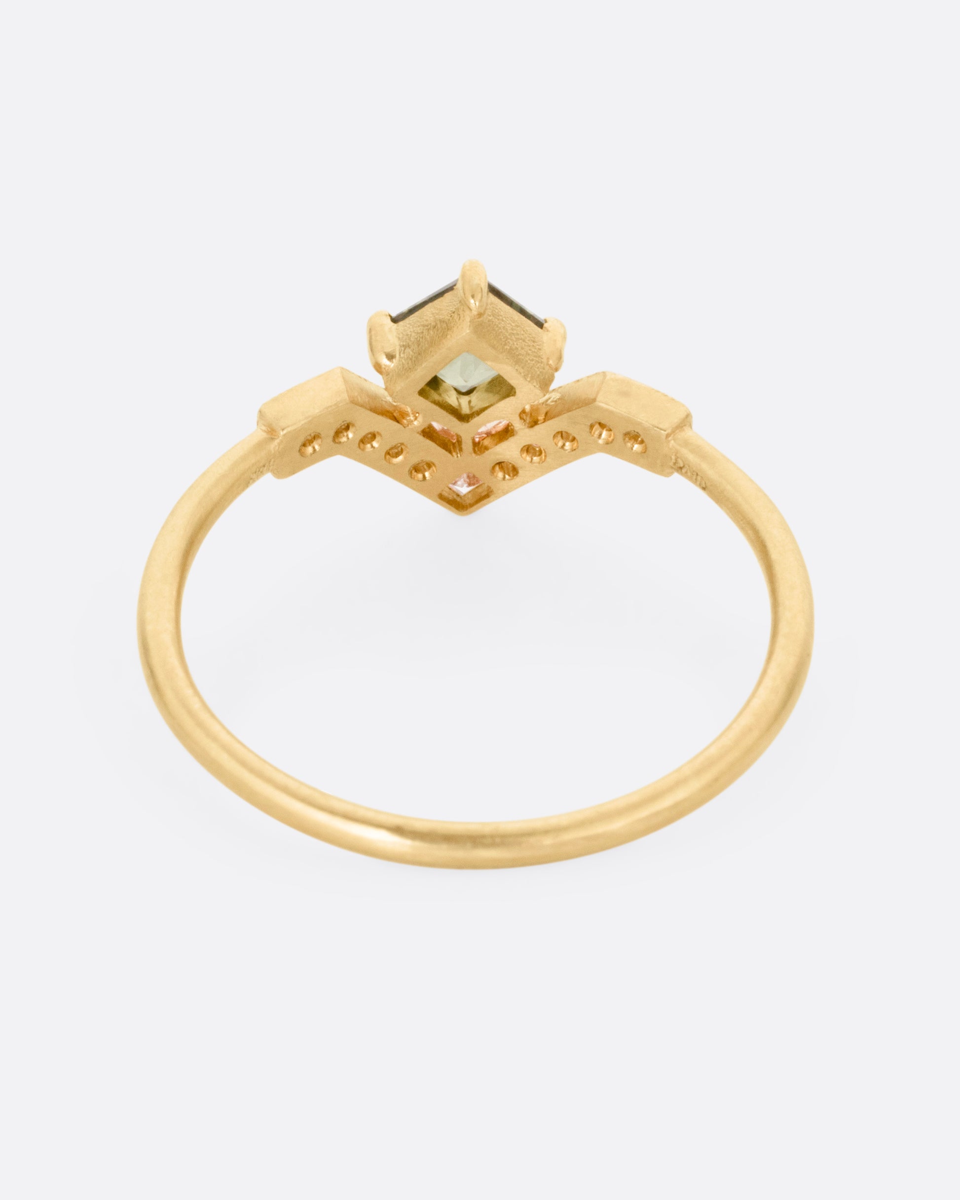 A yellow gold ring with a diamond arch and green sapphire. Shown from the back.