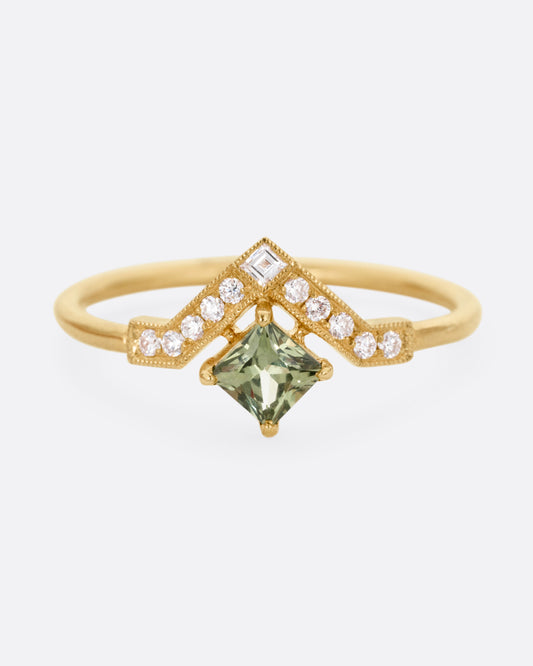 A yellow gold ring with a diamond arch and green sapphire. Shown from the front.