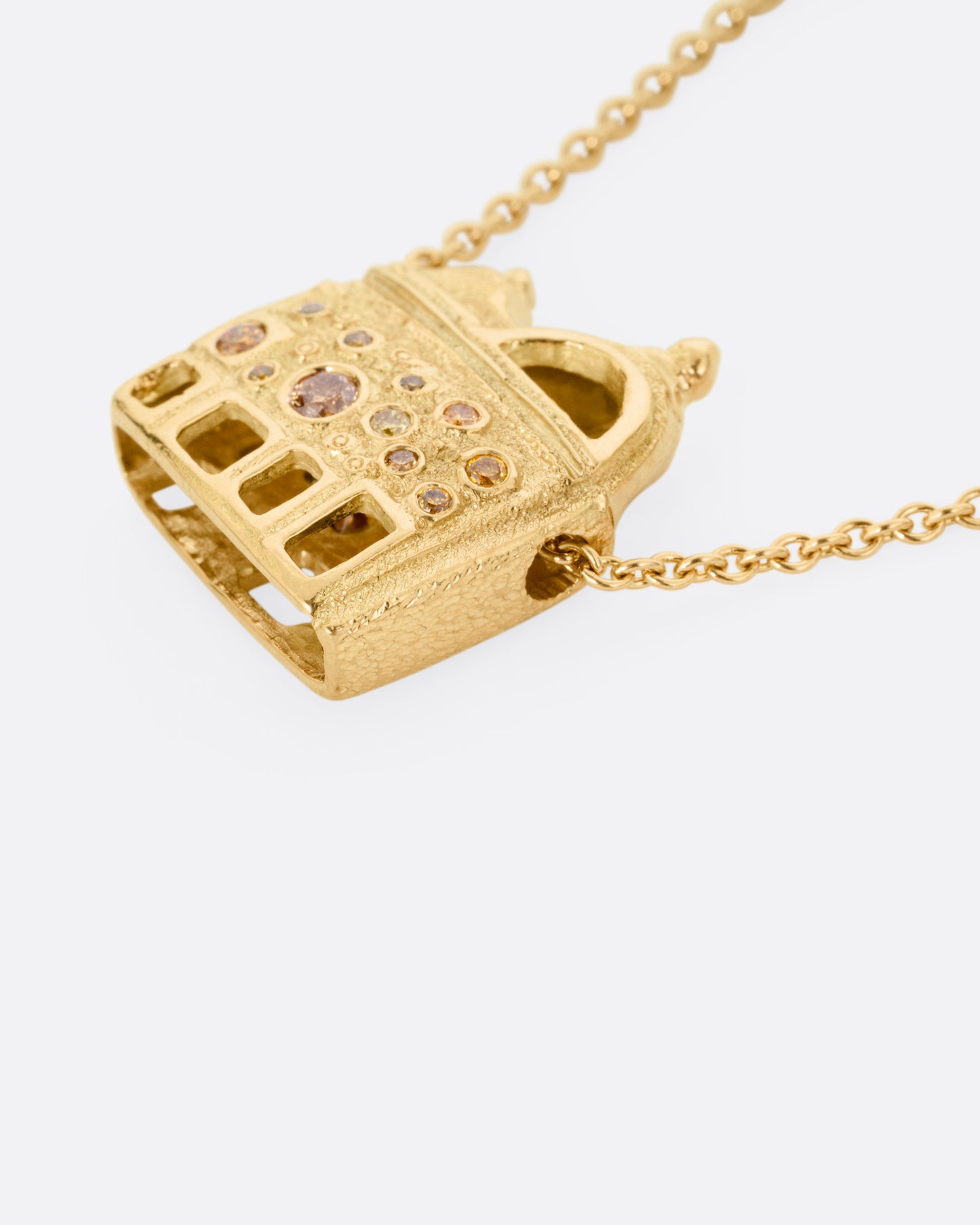 A yellow gold cable chain with a house shaped pendant with open windows and multicolored diamonds, shown from the back.