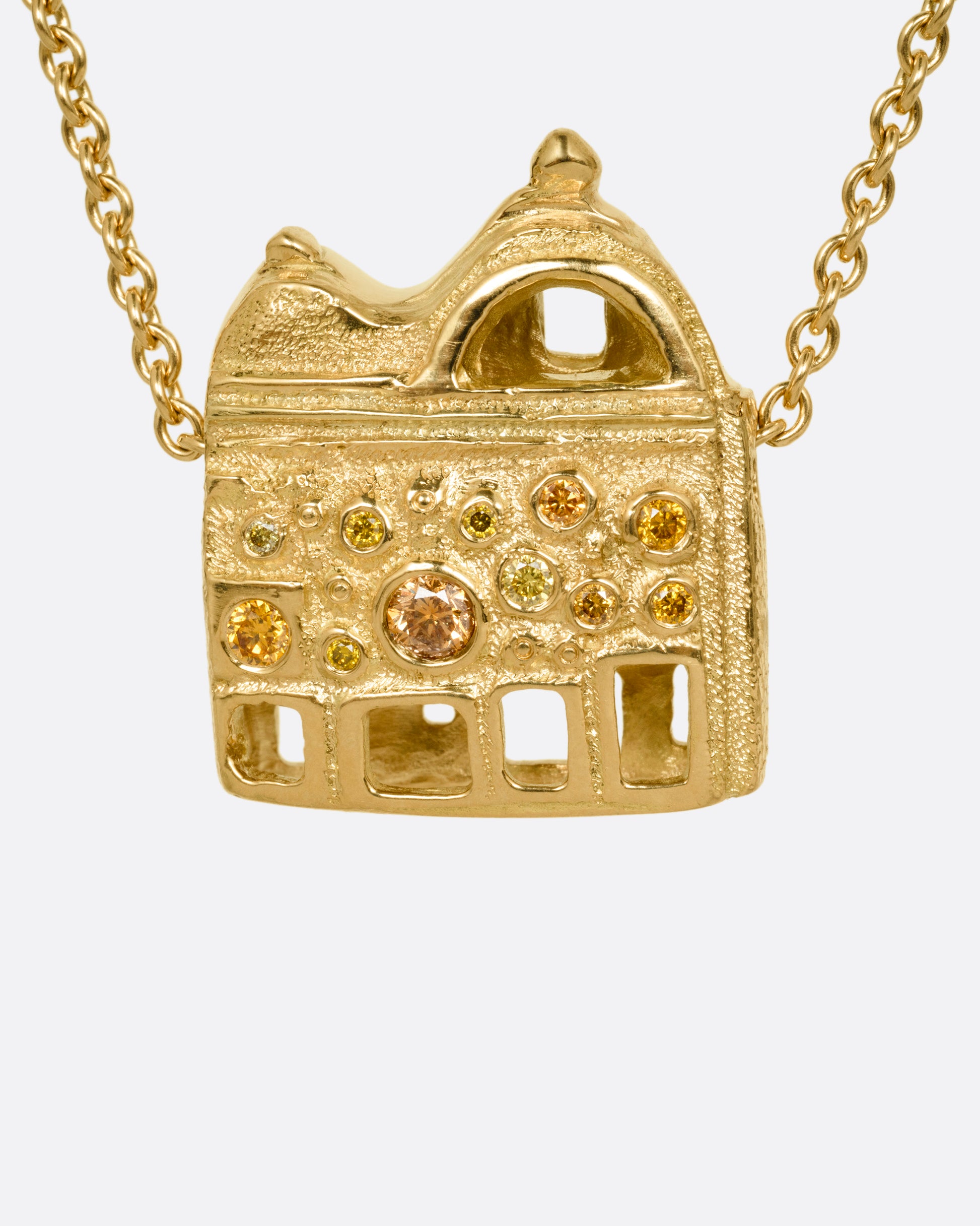 A yellow gold cable chain with a house shaped pendant with open windows and multicolored diamonds, shown from the back.