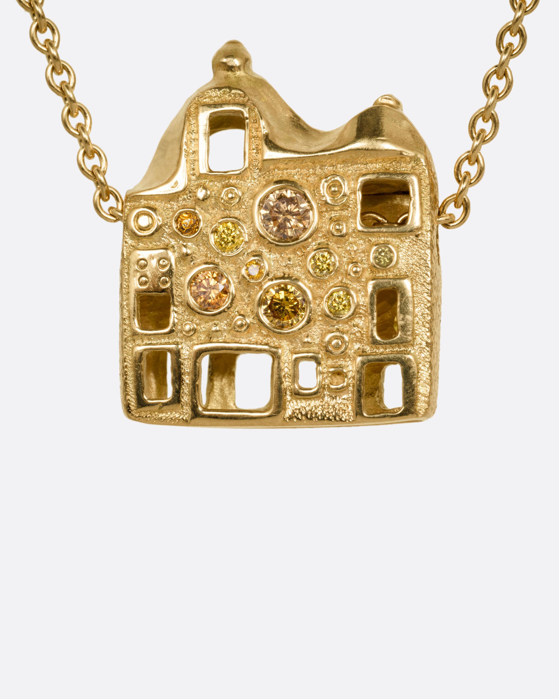 A yellow gold cable chain with a house shaped pendant with open windows and multicolored diamonds, shown from the front.