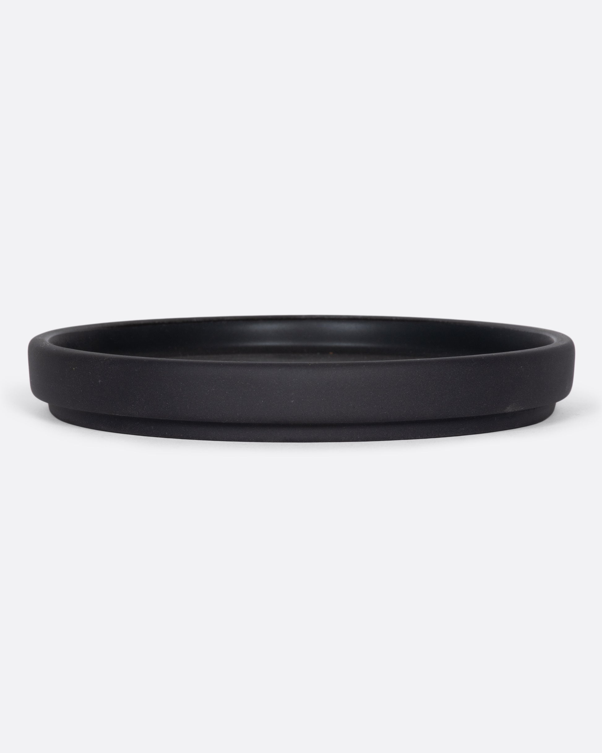 This black ceramic plate with a raised lip and matte black finish looks beautiful with tall candles and works great for small plants, too.