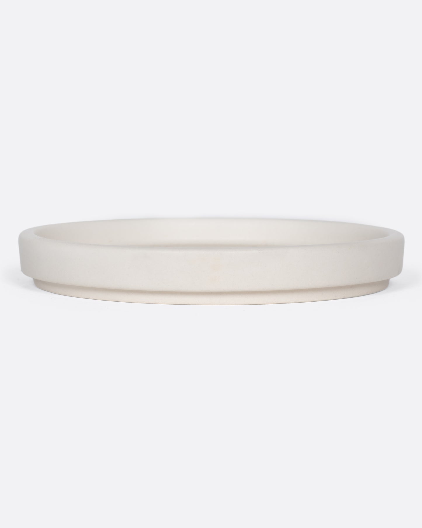 This creamy white ceramic plate with a raised lip and matte white finish looks beautiful with tall candles and works great for small plants, too.