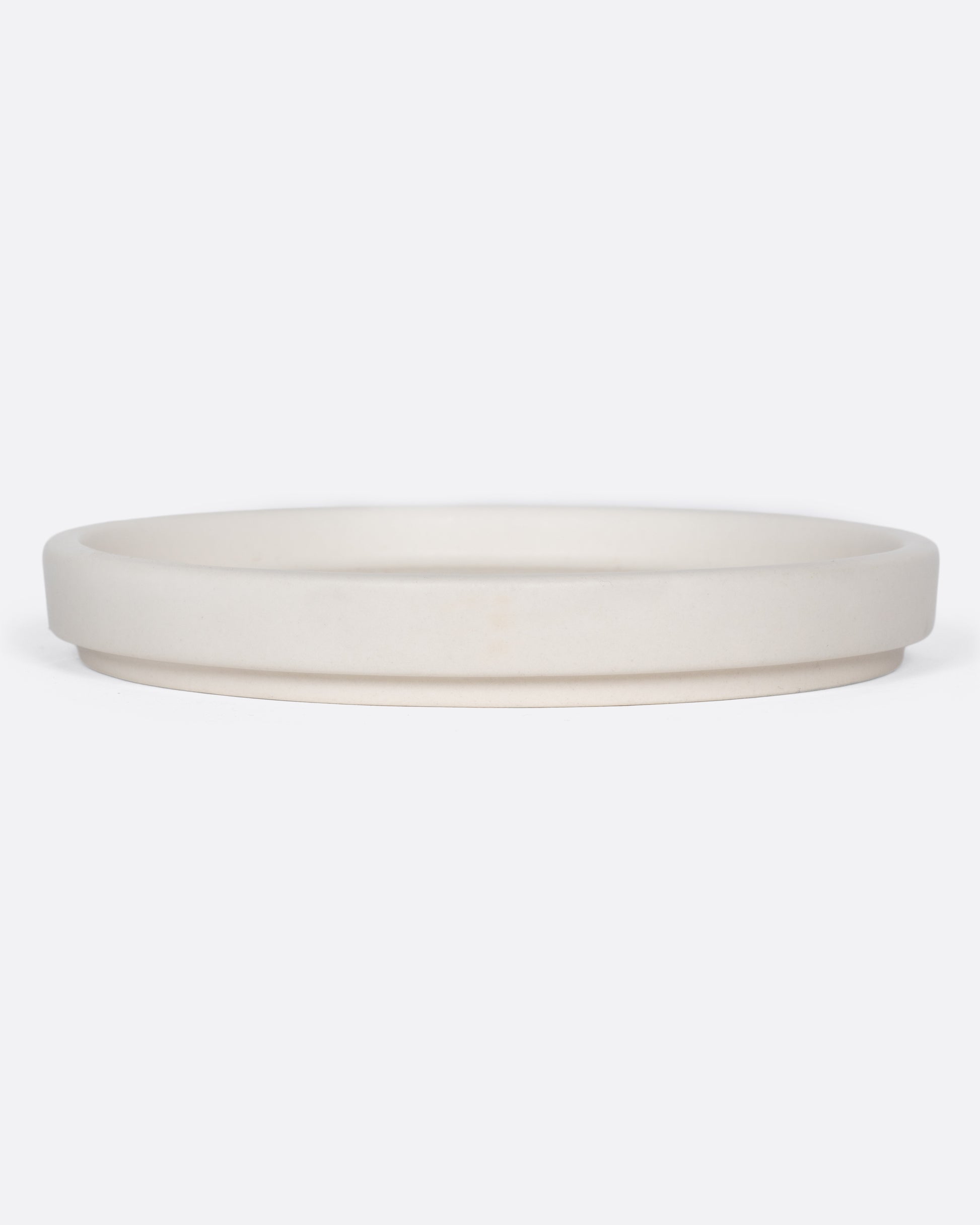 This creamy white ceramic plate with a raised lip and matte white finish looks beautiful with tall candles and works great for small plants, too.