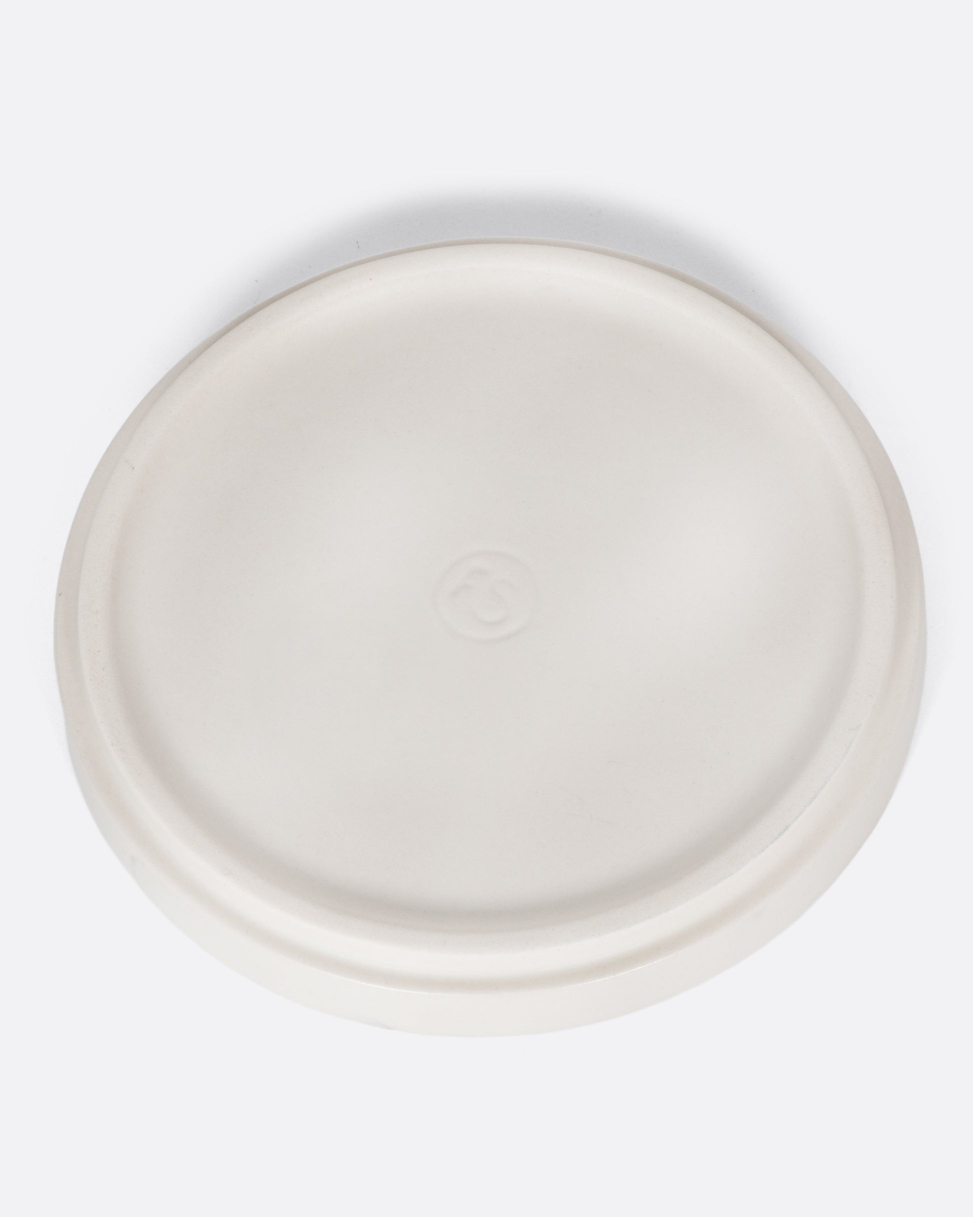 This creamy white ceramic plate with a raised lip and matte white finish looks beautiful with tall candles and works great for small plants, too.