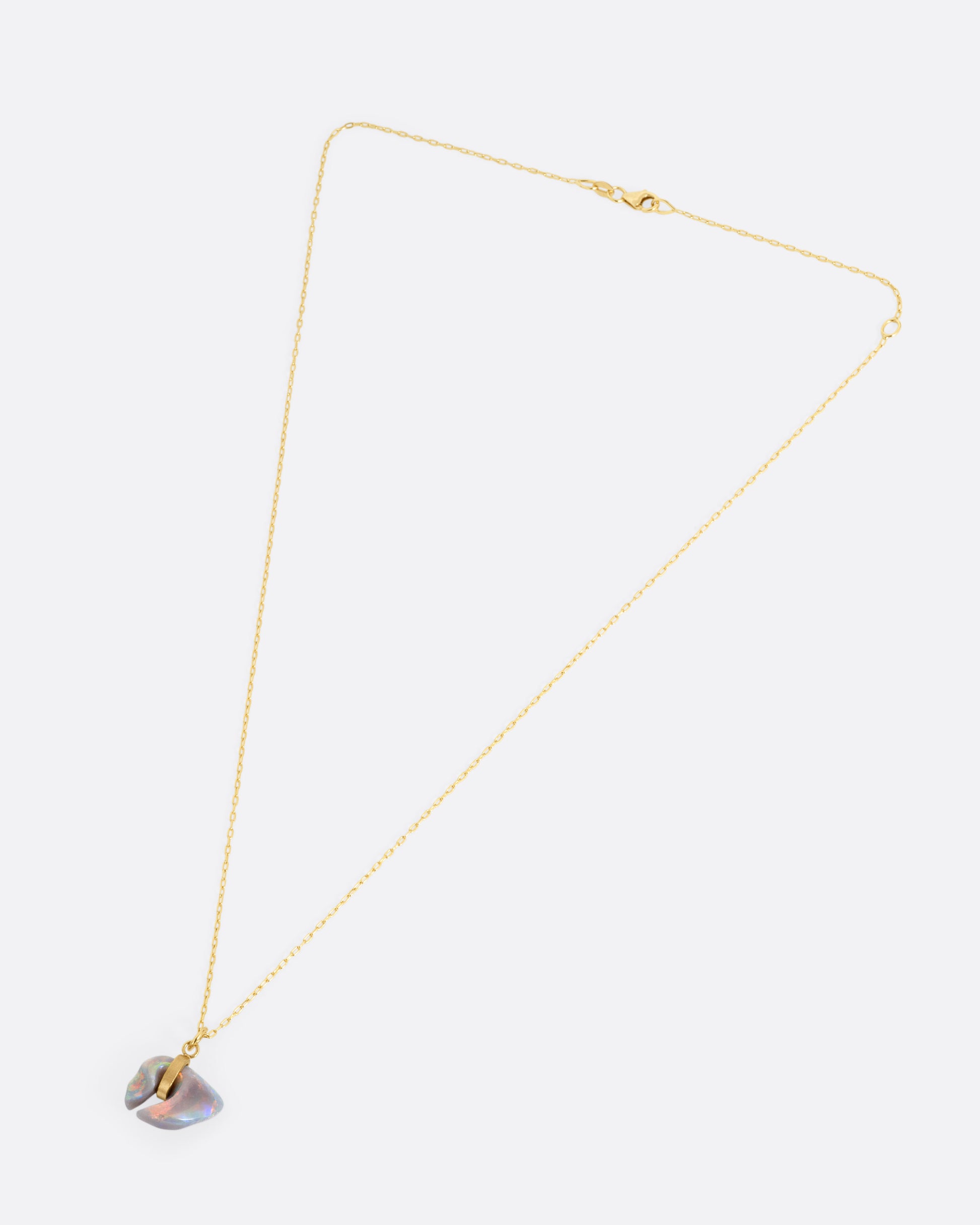 A yellow gold cable chain with a claw shaped Australian opal belted in gold, shown from the front.