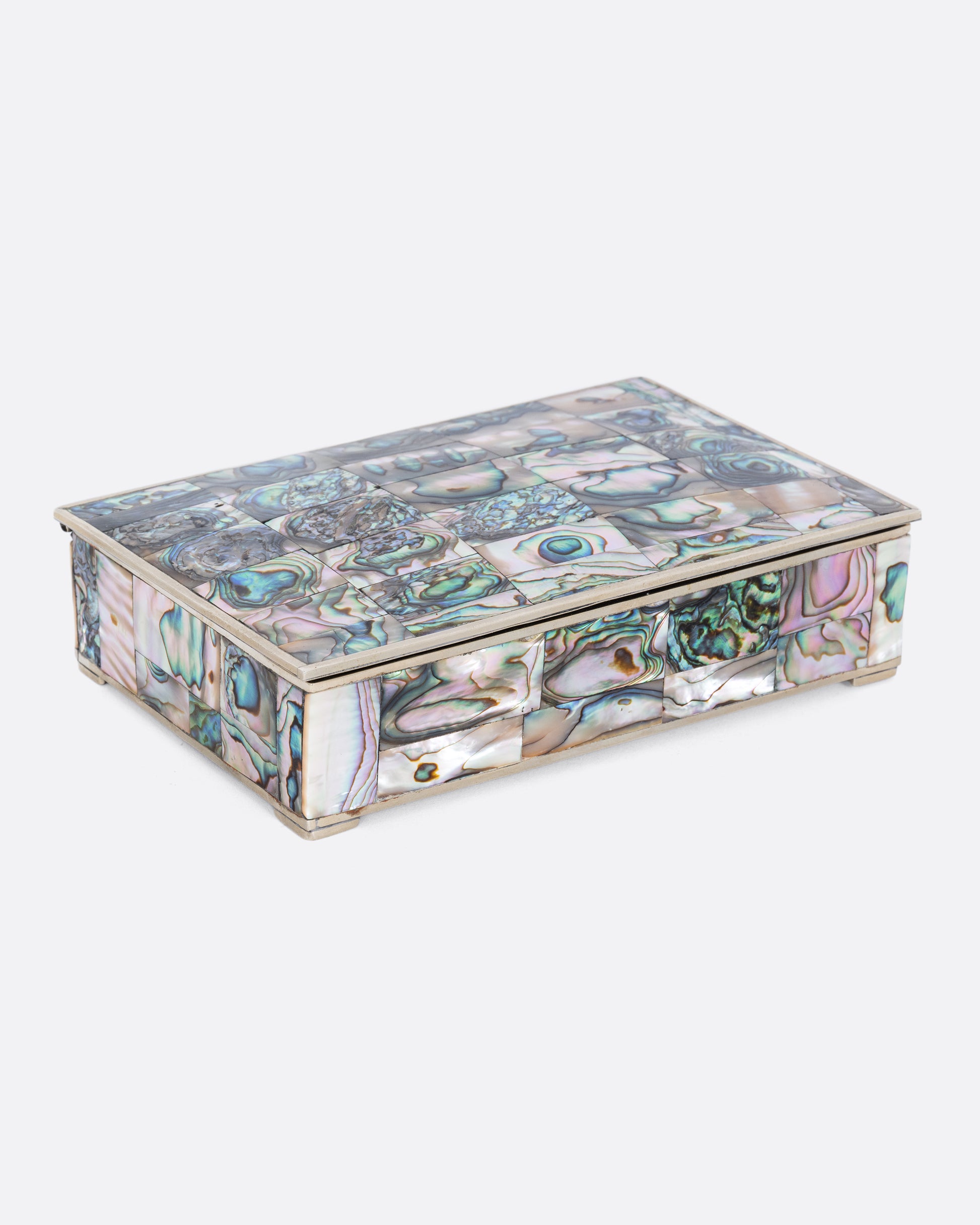 An alpaca silver box with abalone inlay and a rosewood interior. Shown closed, from the side.