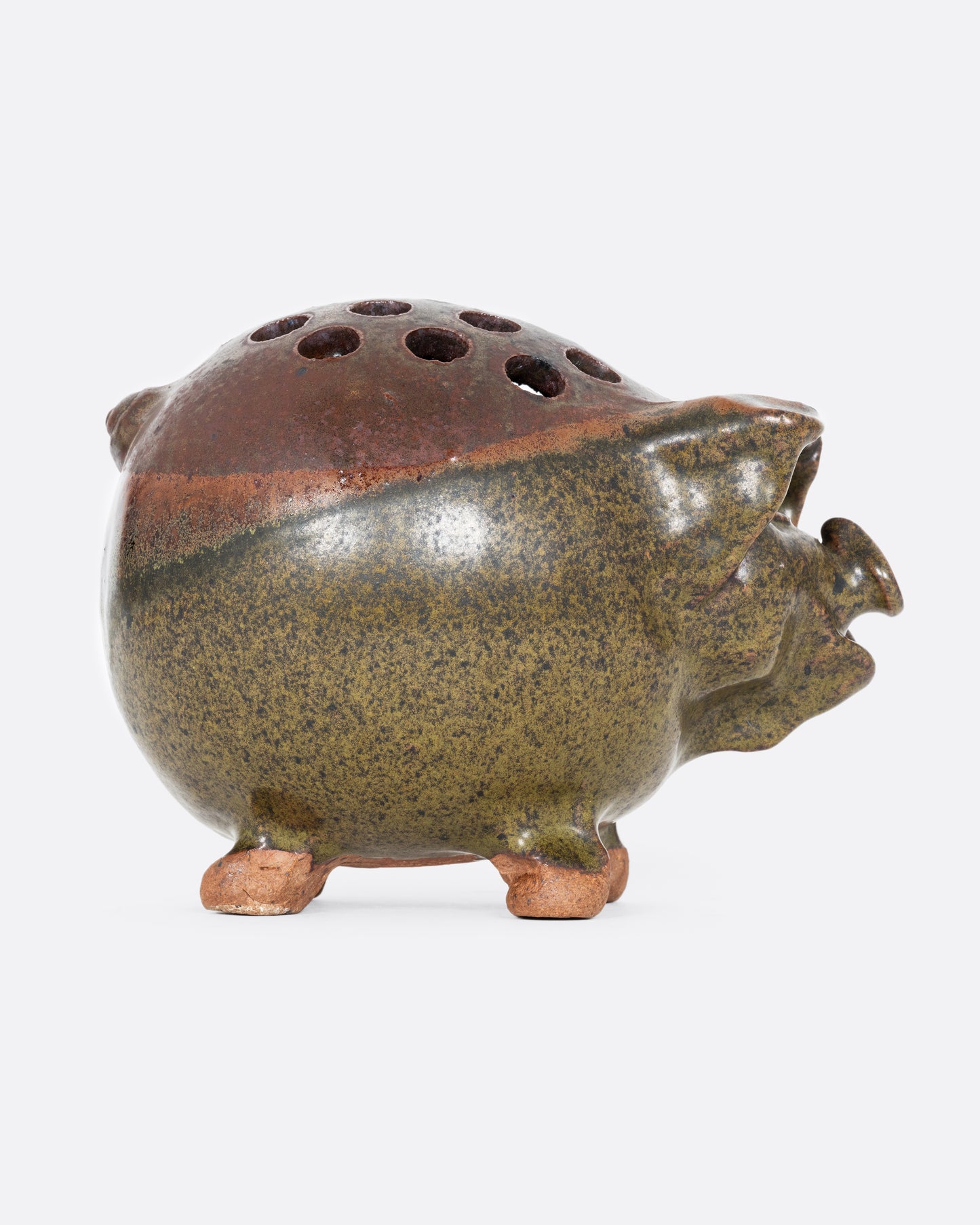 A green ceramic frog flower vase that's a pig! Shown from the side.