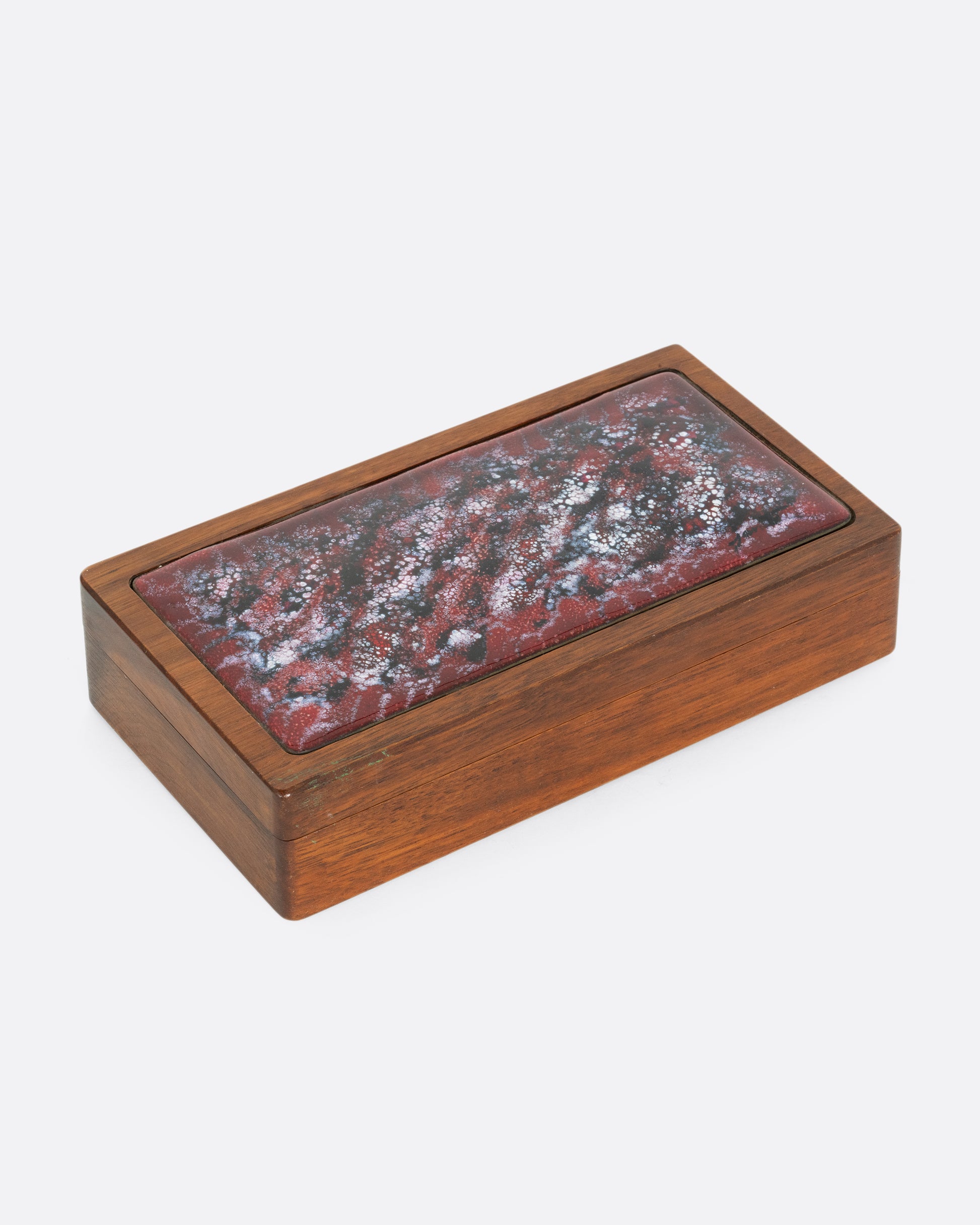 A wooden box with an enameled copper lid. Shown from the side.