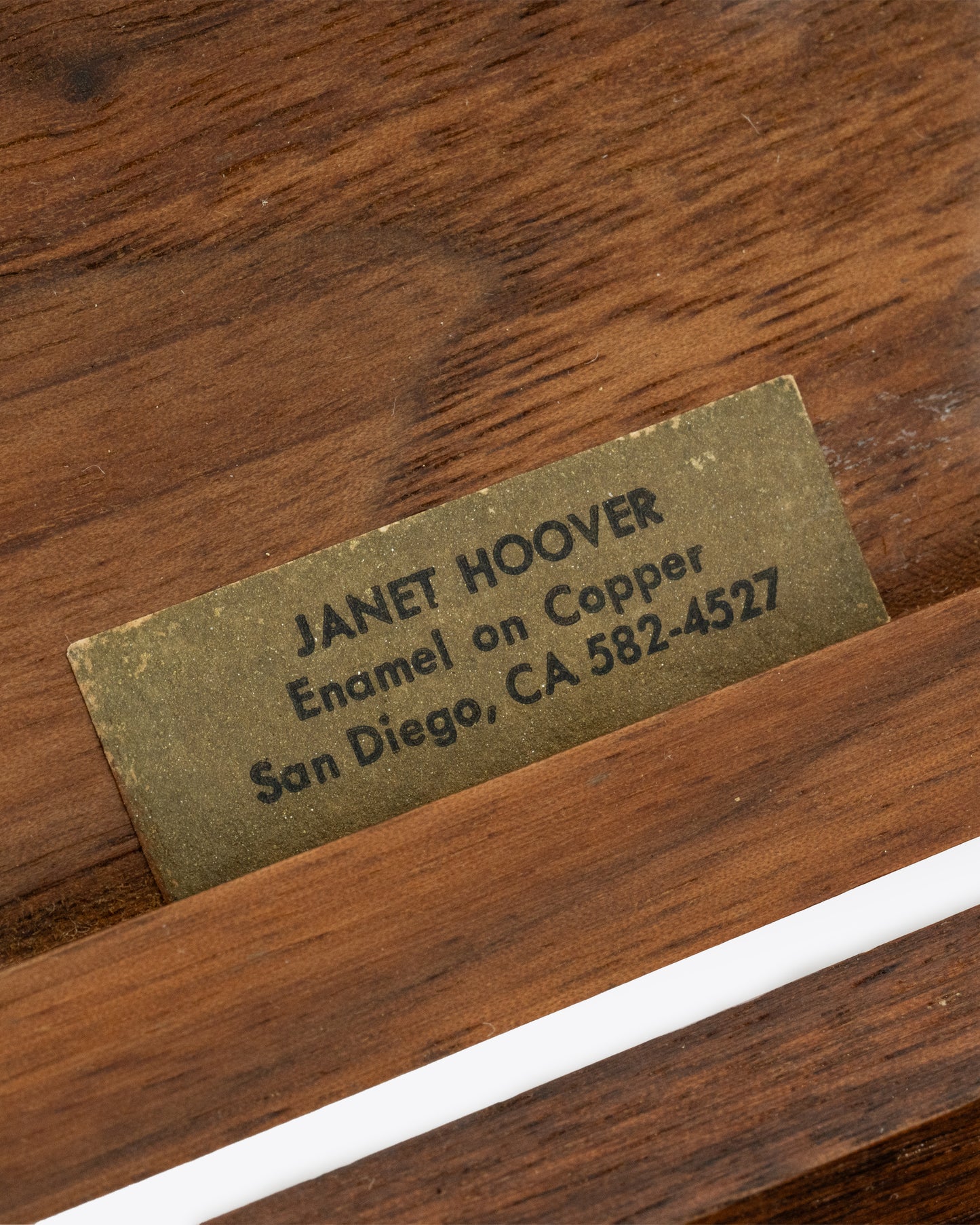 A wooden box with an enameled copper lid. Tag inside, shown close up.