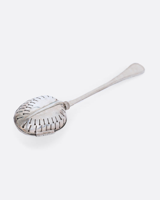 A sterling silver spoon tea infuser with a screw mechanism. Shown laying flat.