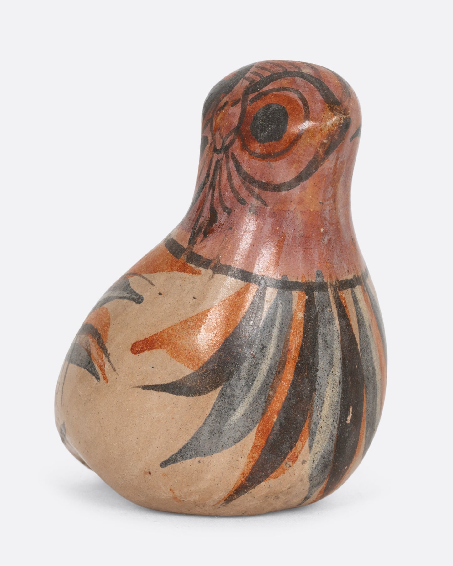 A hand painted tonala style owl figurine. Shown from the side.