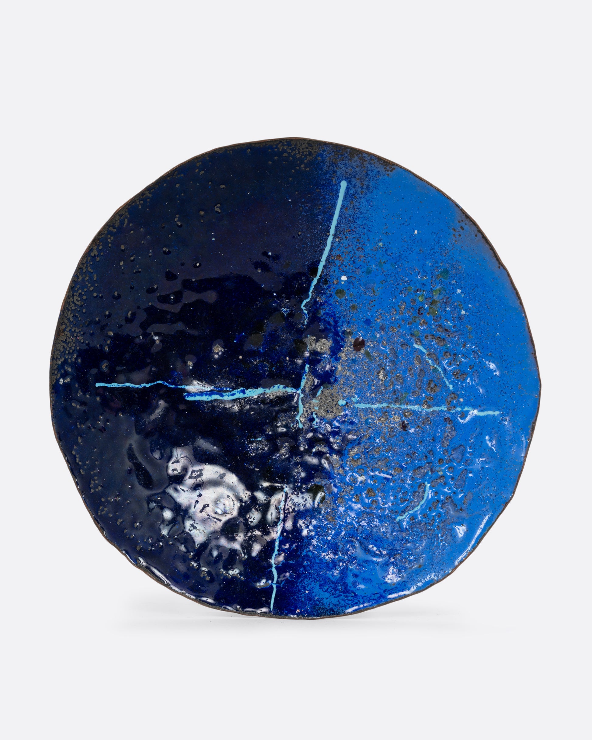 A copper plate with textured two tone blue enamel and an abstract design. Shown from the front.