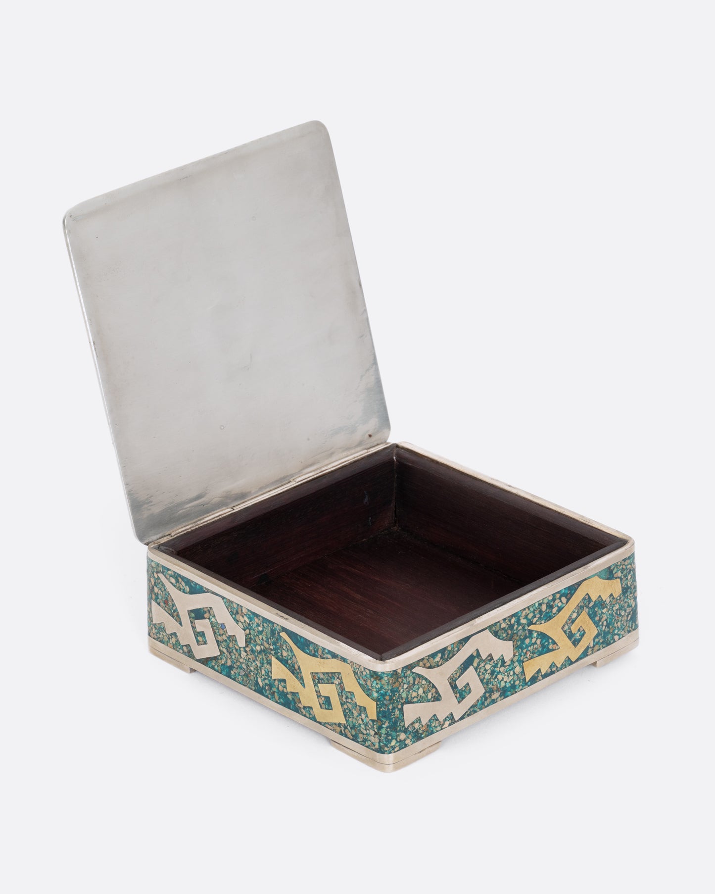 An alpaca silver box with copper and brass geometric inlay and sodalite chips as the blue background. Shown open, showcasing the wooden interior.