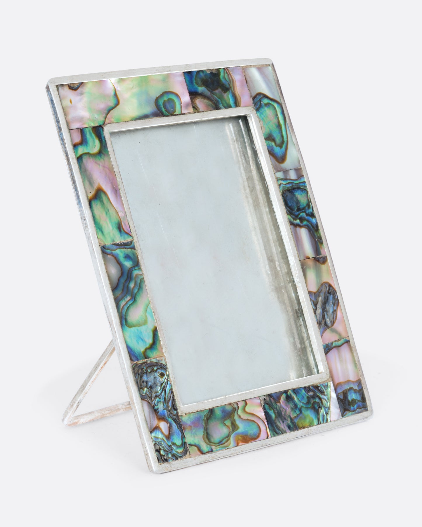 An alpaca silver rectangular faced frame with abalone inlay. Shown from the side.