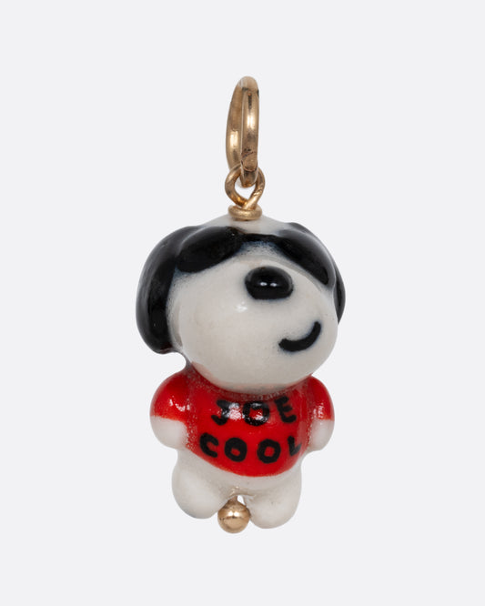 A "Joe Cool" porcelain Snoopy charm with a yellow gold bail. Shown from the front.