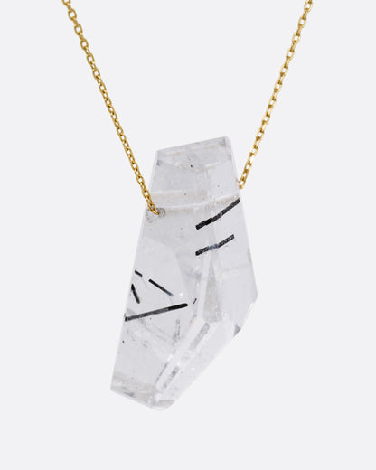 A drilled tourmalinated quartz on a fine yellow gold chain. Shown from the side.