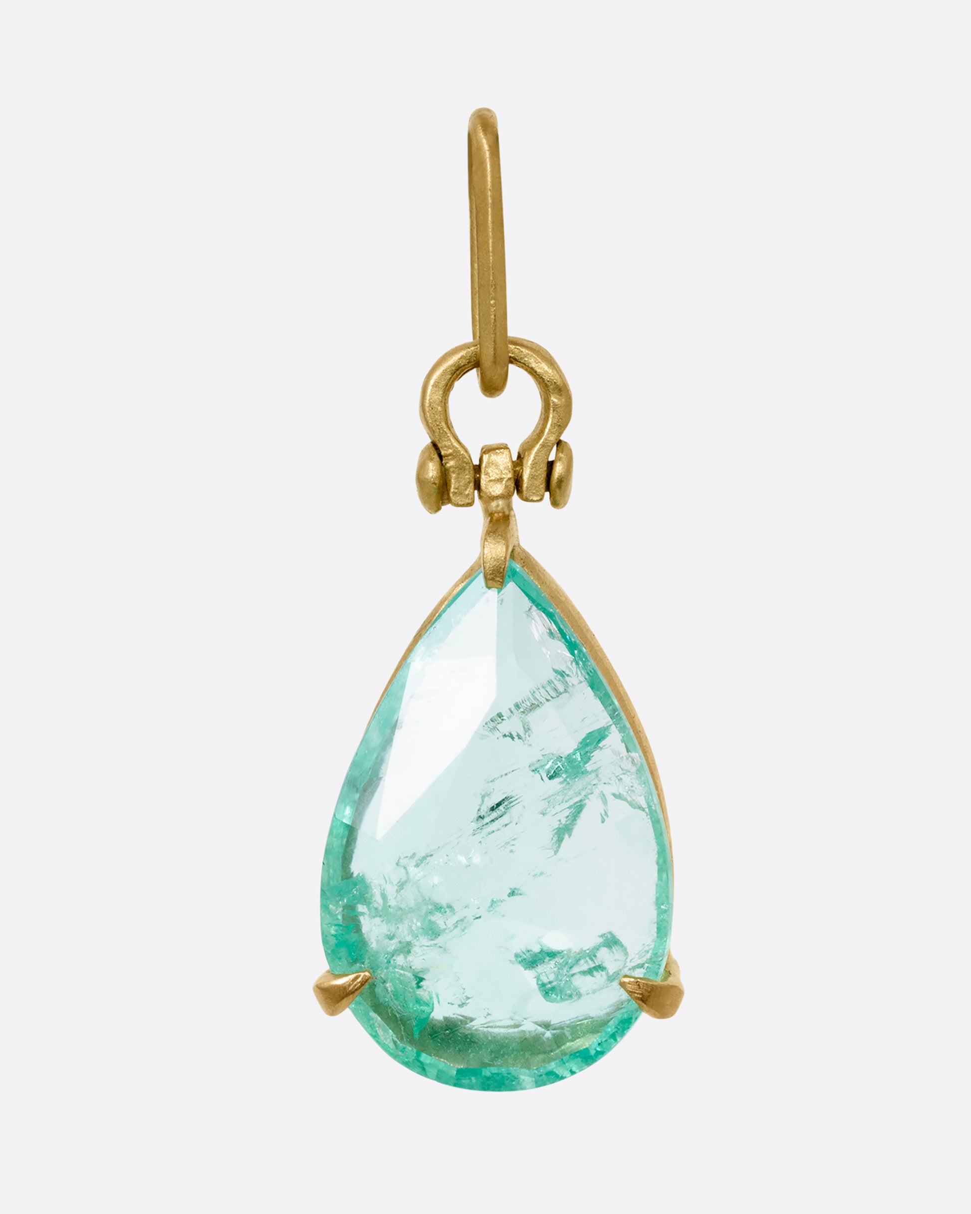 A yellow gold tear drop shaped prong set emerald pendant. Shown from the front.