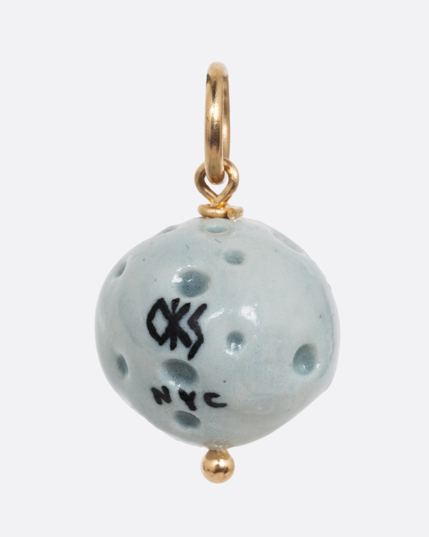 A blue full moon porcelain charm with a yellow gold bail. Shown from the back.