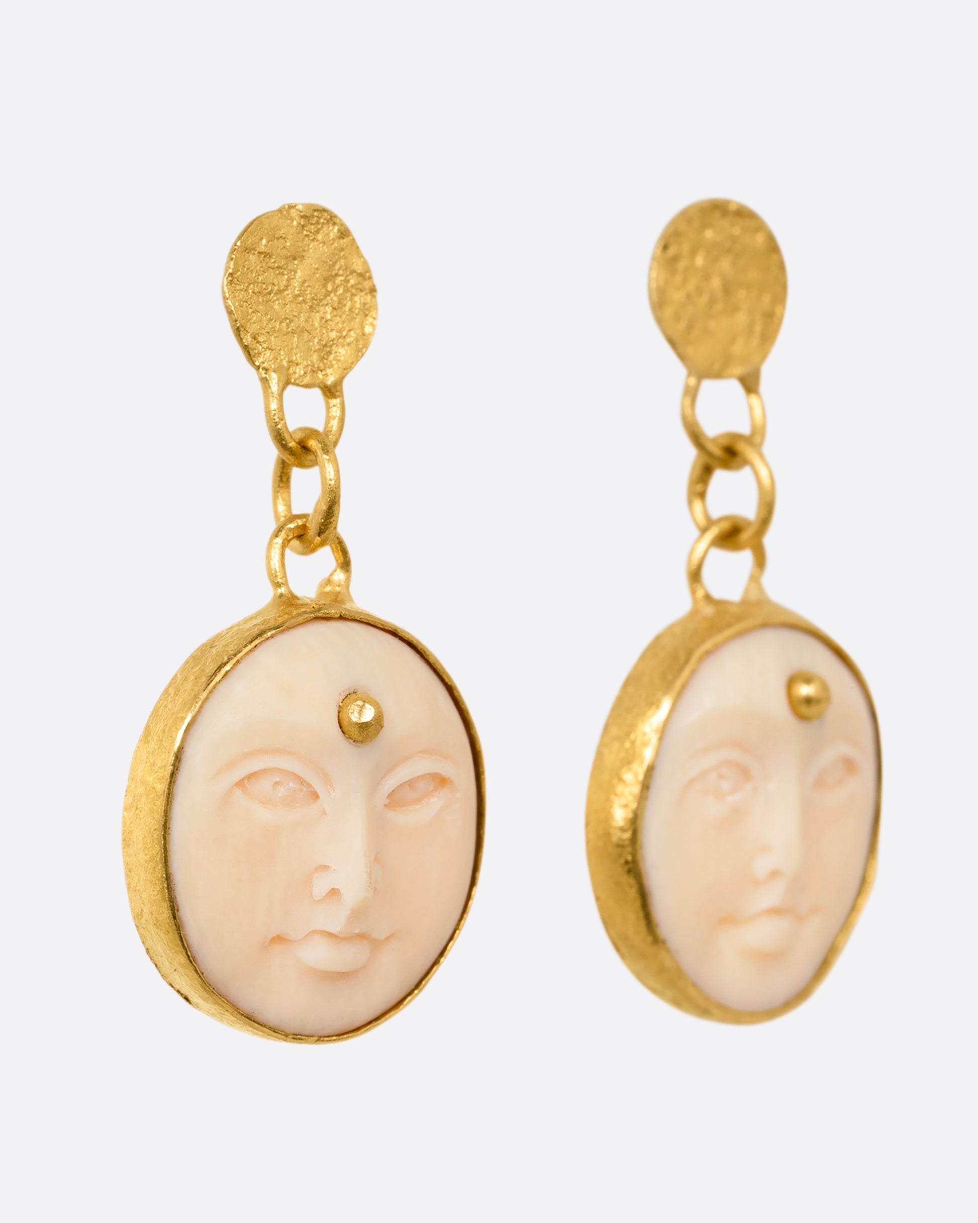 yellow gold carved bone moon face earrings shown from the side