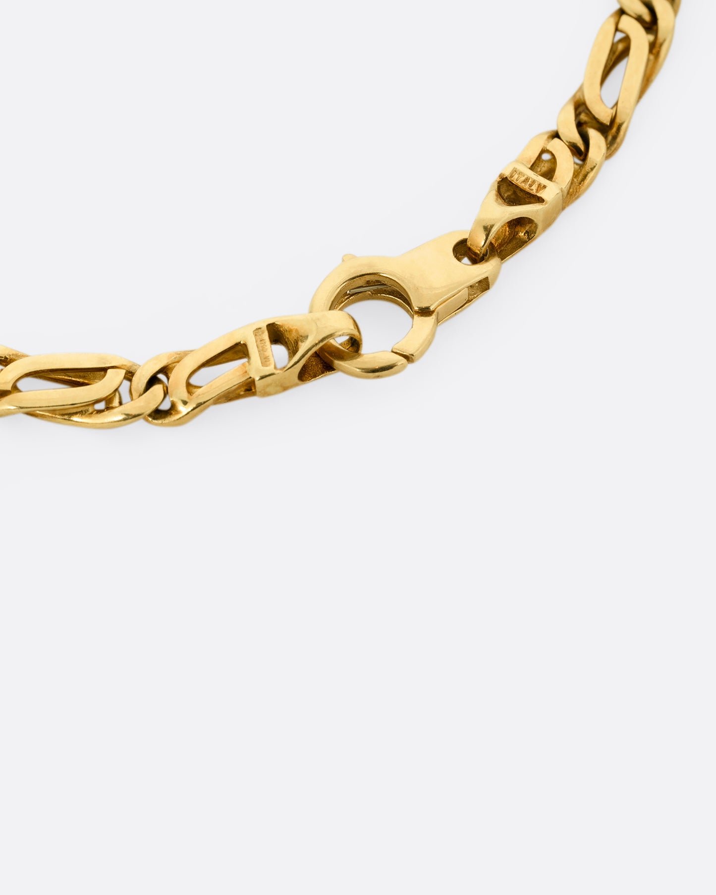 A yellow gold infinity chain link necklace. Shown close up of the clasp.